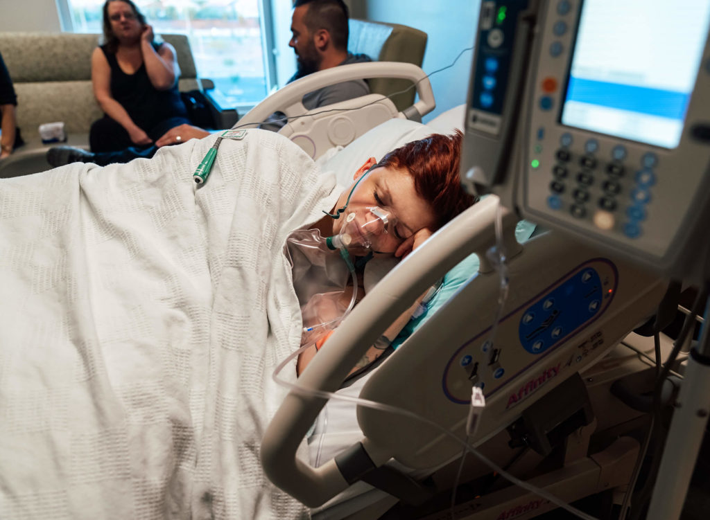resting during labor with an oxygen face mask on 