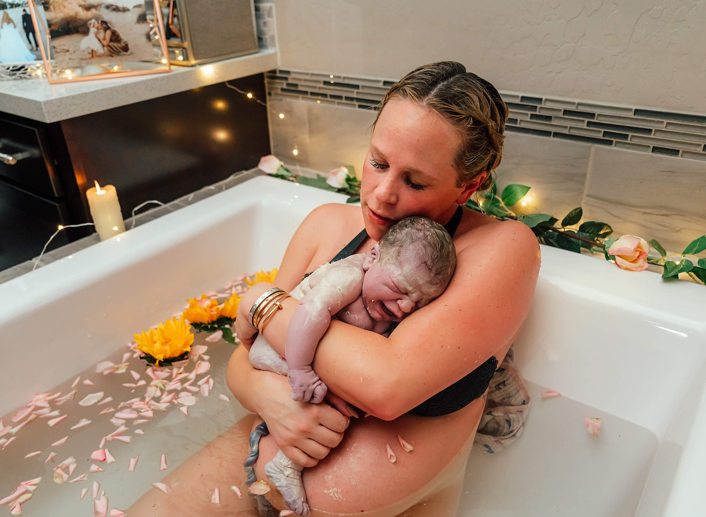 emotional mother holding her baby after birth in water