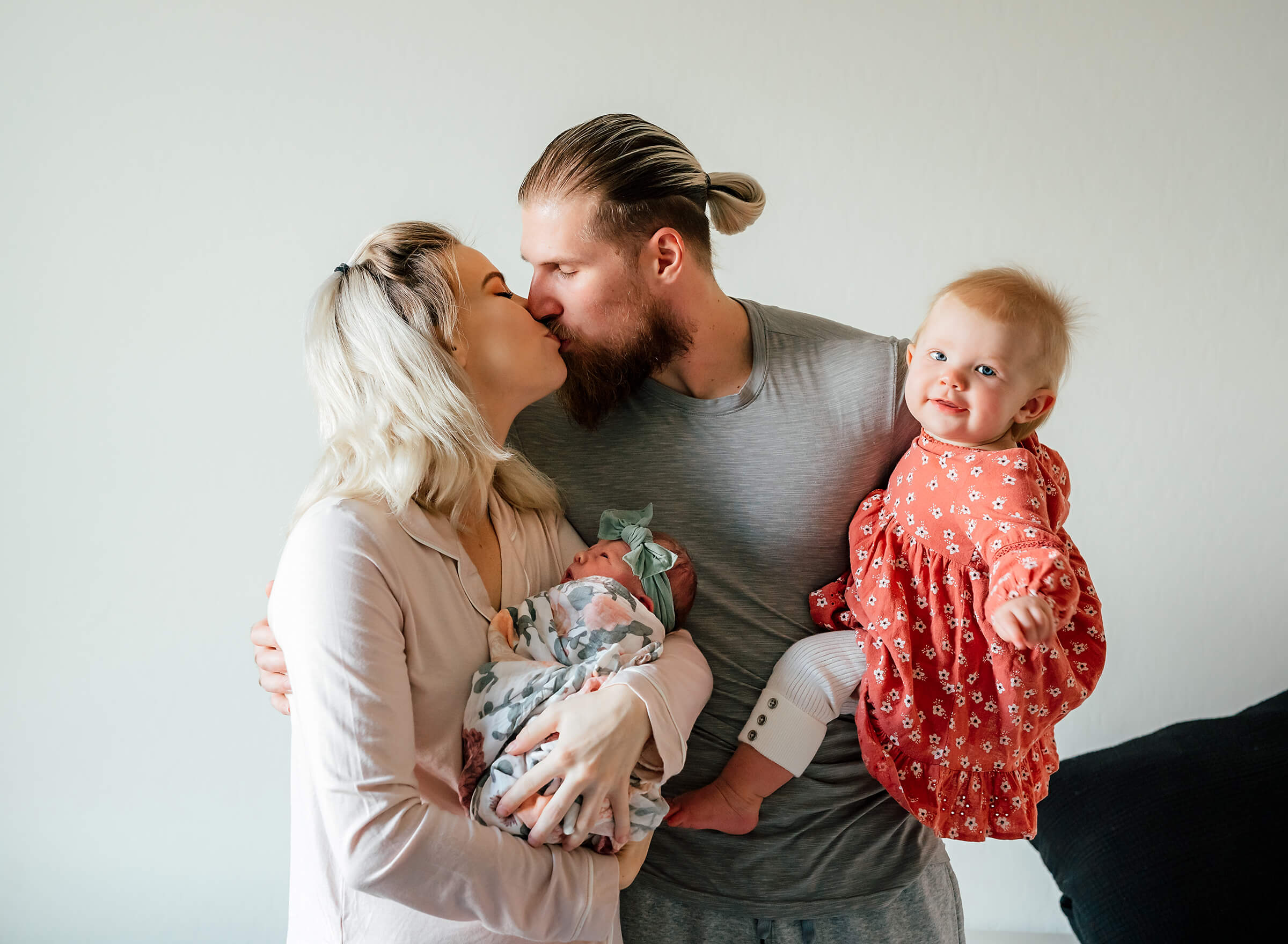 mom and dad kissing in group images with both of their daughters