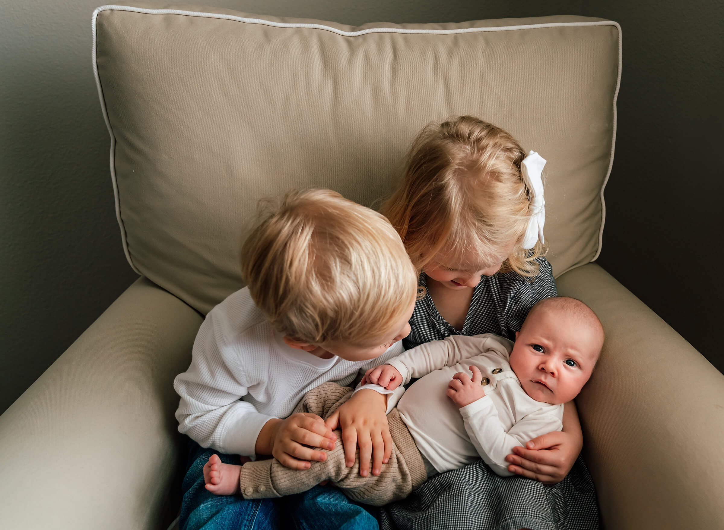 siblings interacting with their new baby brother at home