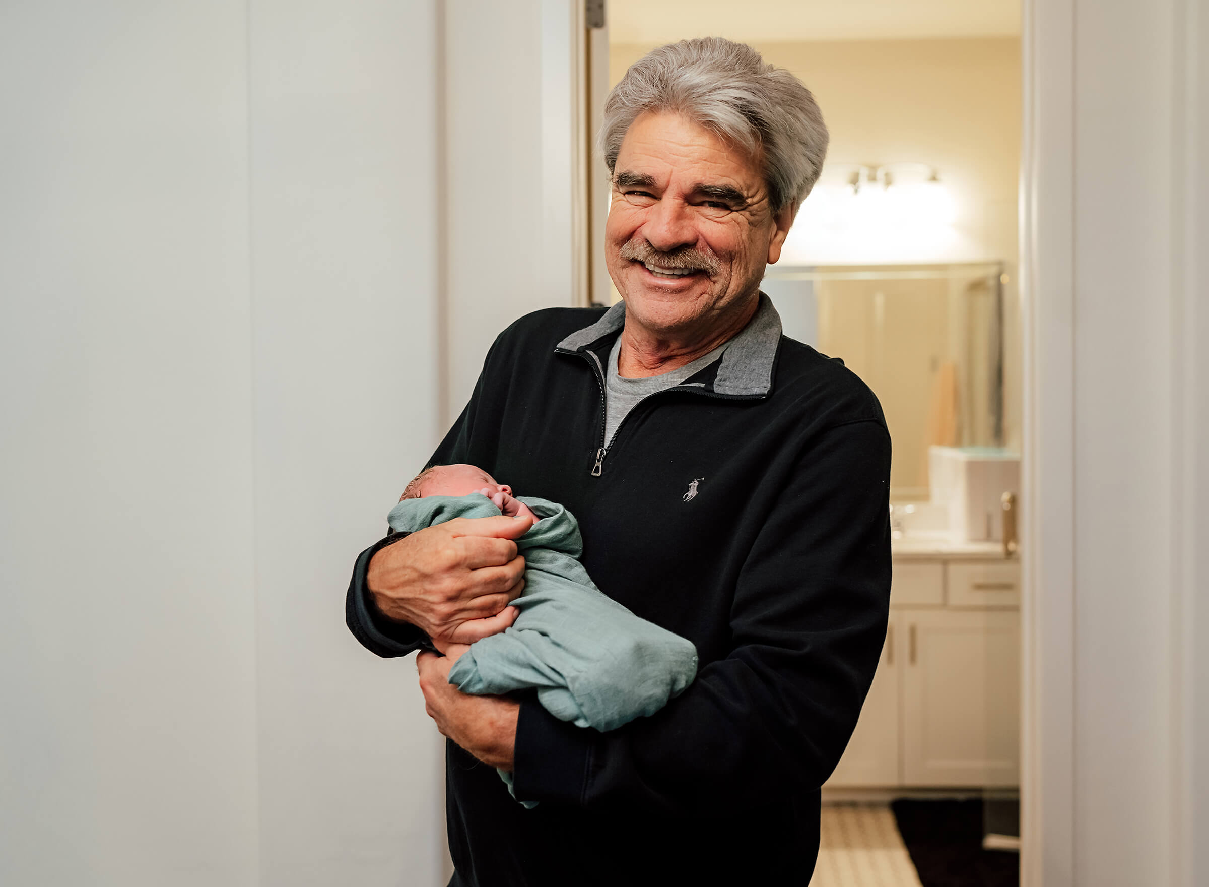 proud grandfather holding his new granddaughter after home birth in Las Vegas