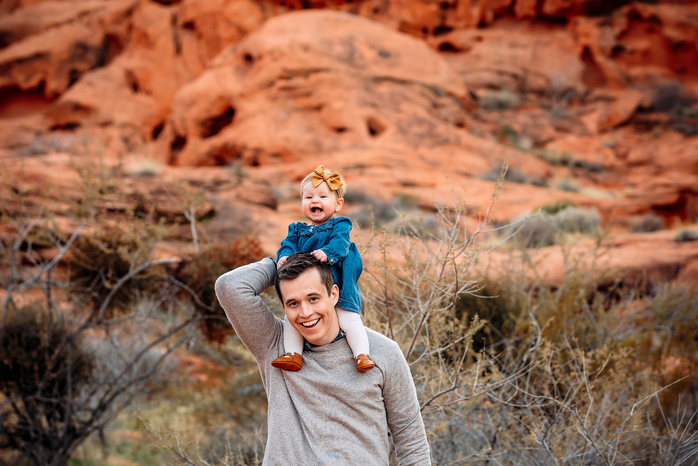 dad holding his daughter on his shoulders during their family session outside of Las Vegas