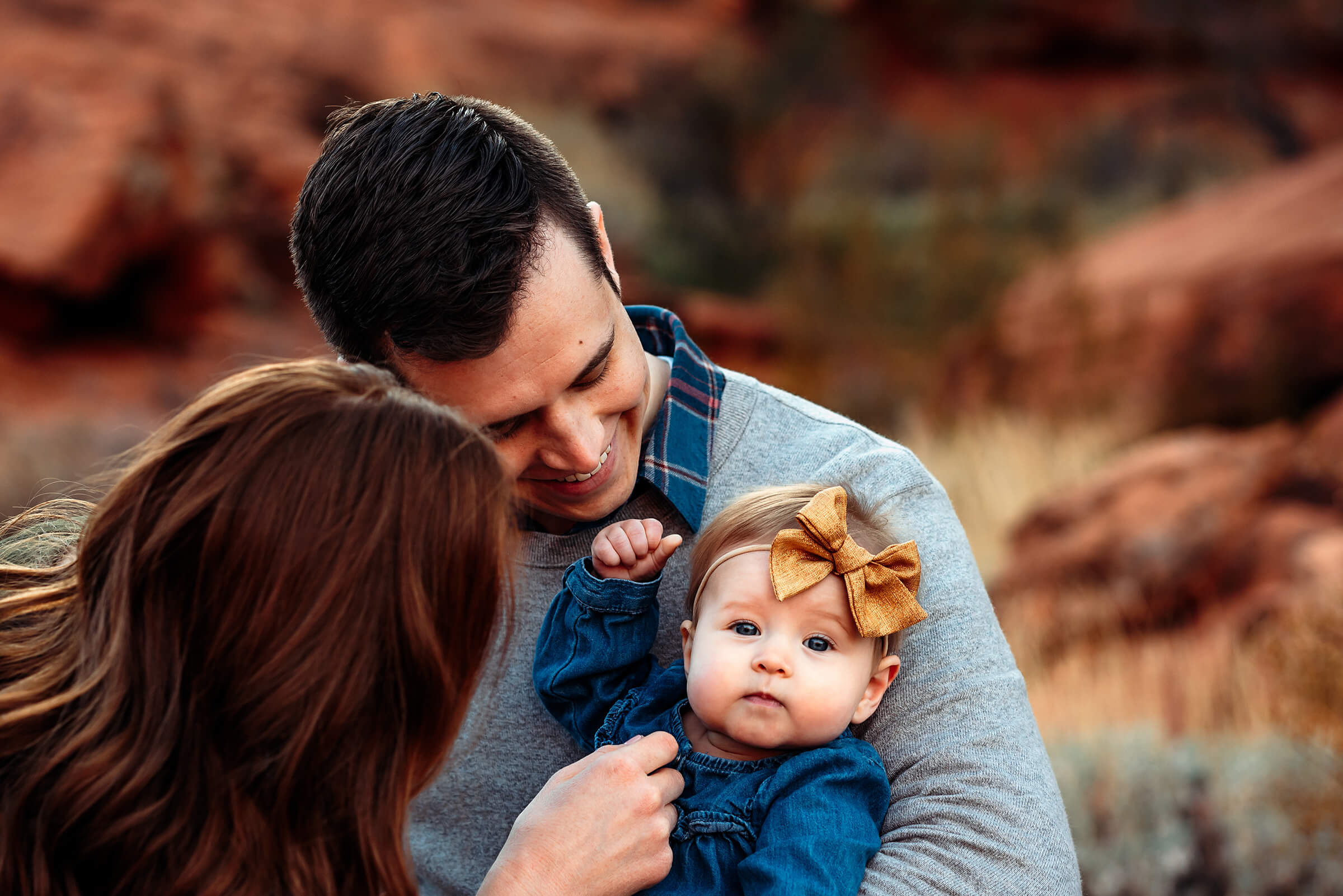 six month old baby in her father's arms during an outdoor family session in Las Vegas