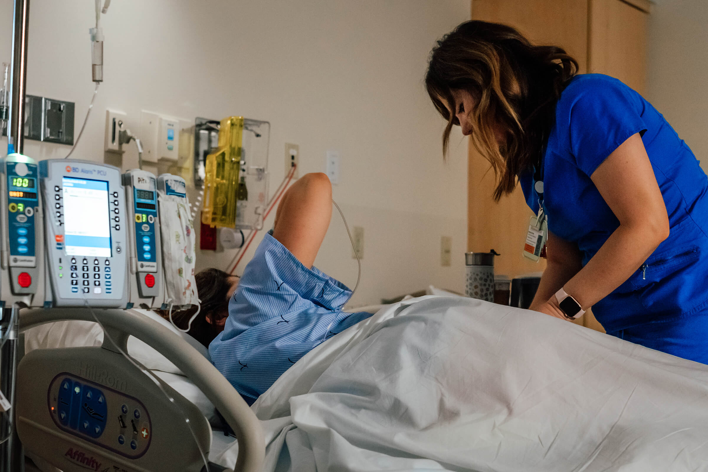 nurse adjusting external monitors on laboring mother in the hospital