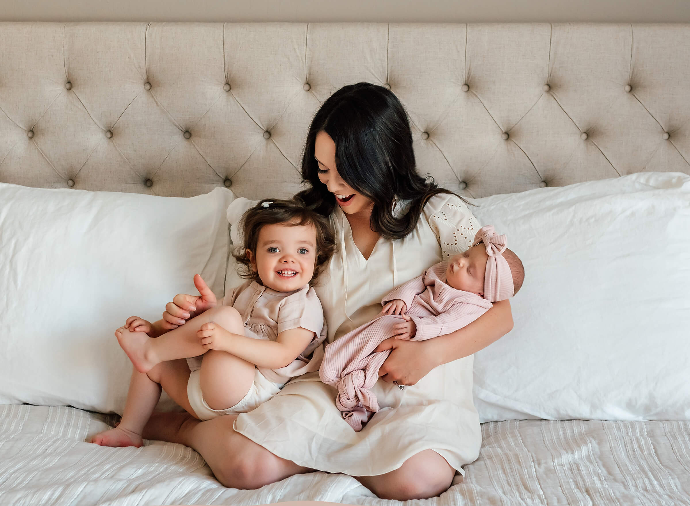 adorable moment between mom and her two daughters during in home newborn session 