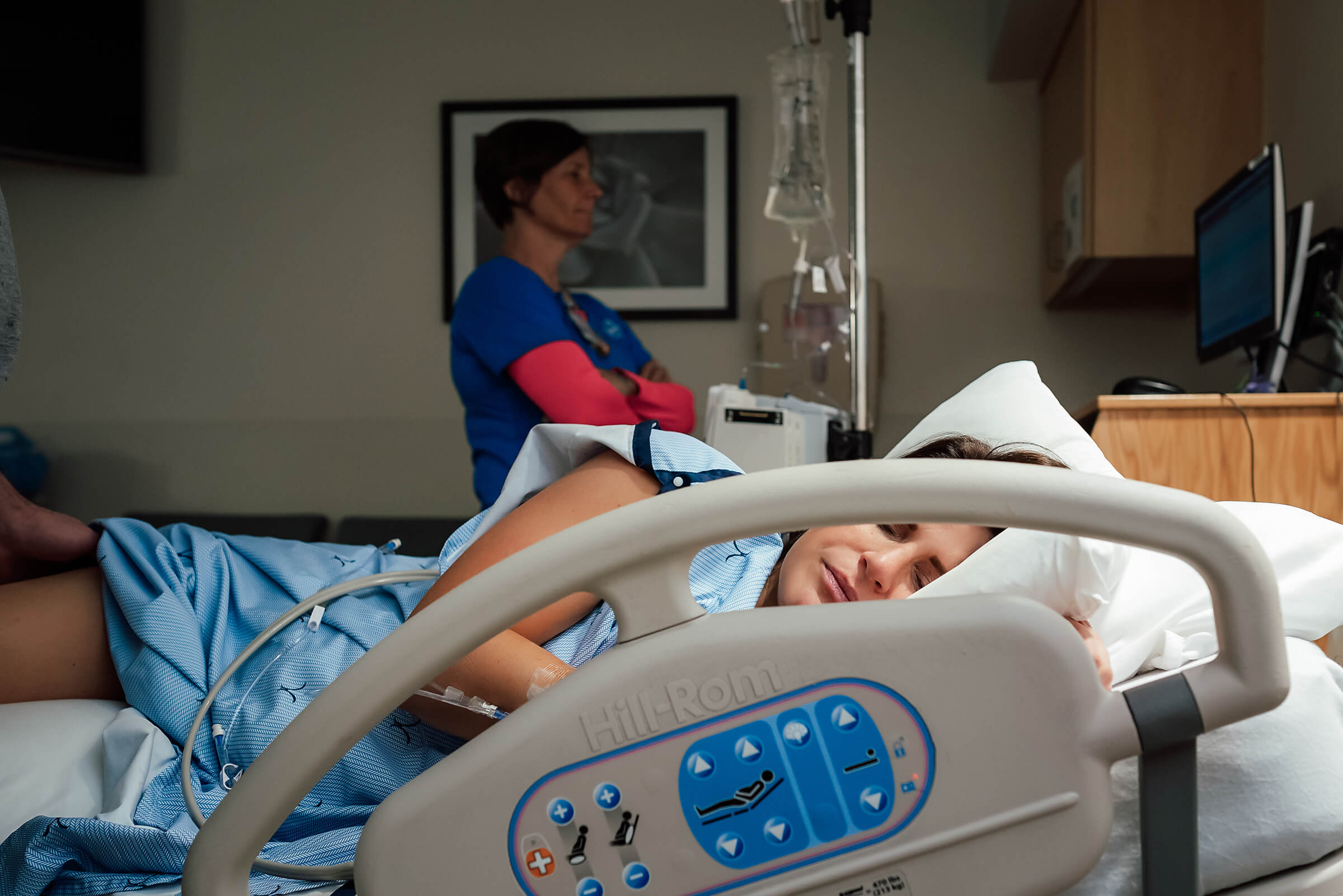 nurse watching fetal monitoring while patient is laboring in her bed