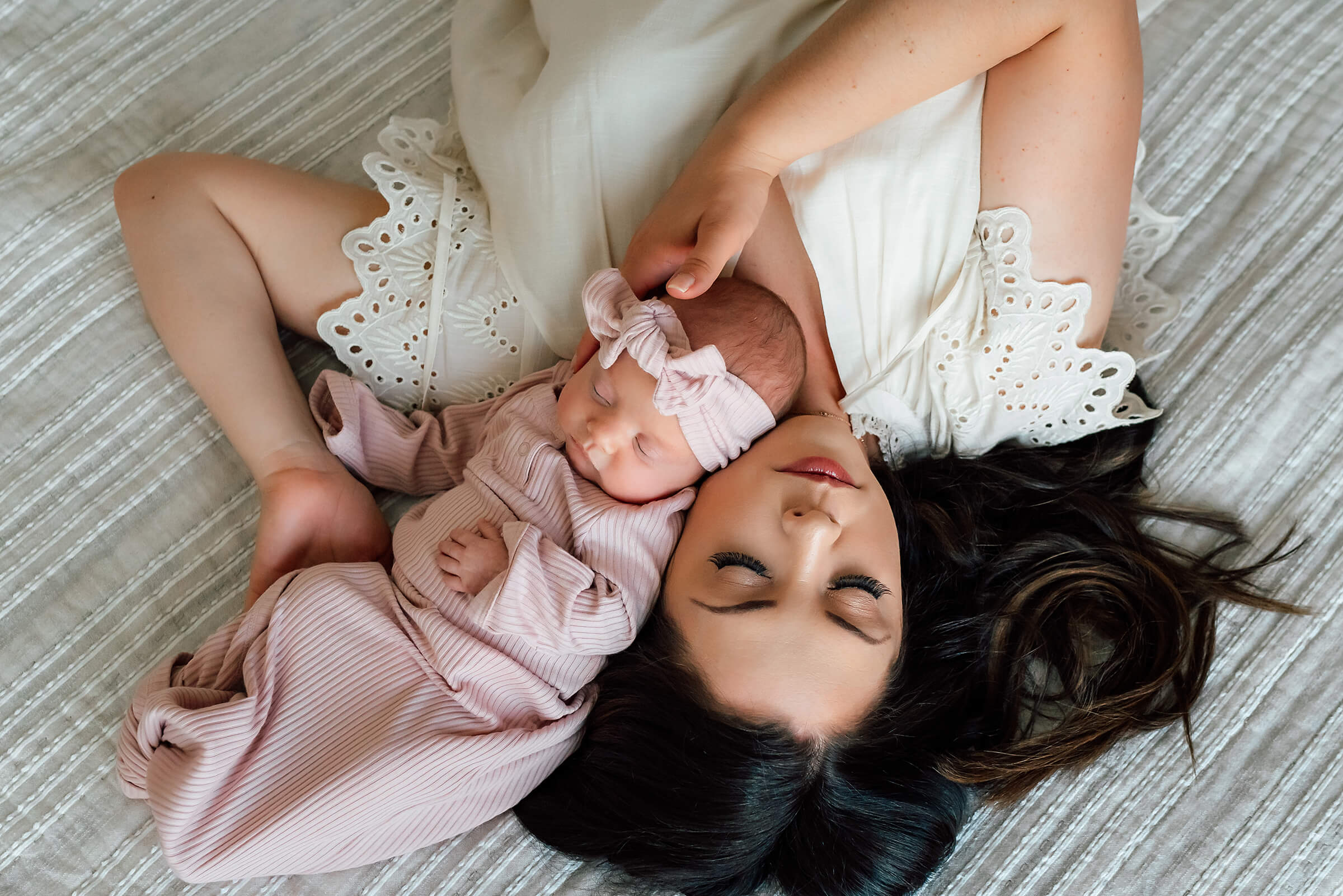 beautiful pose with mom and baby on bed in home newborn session 