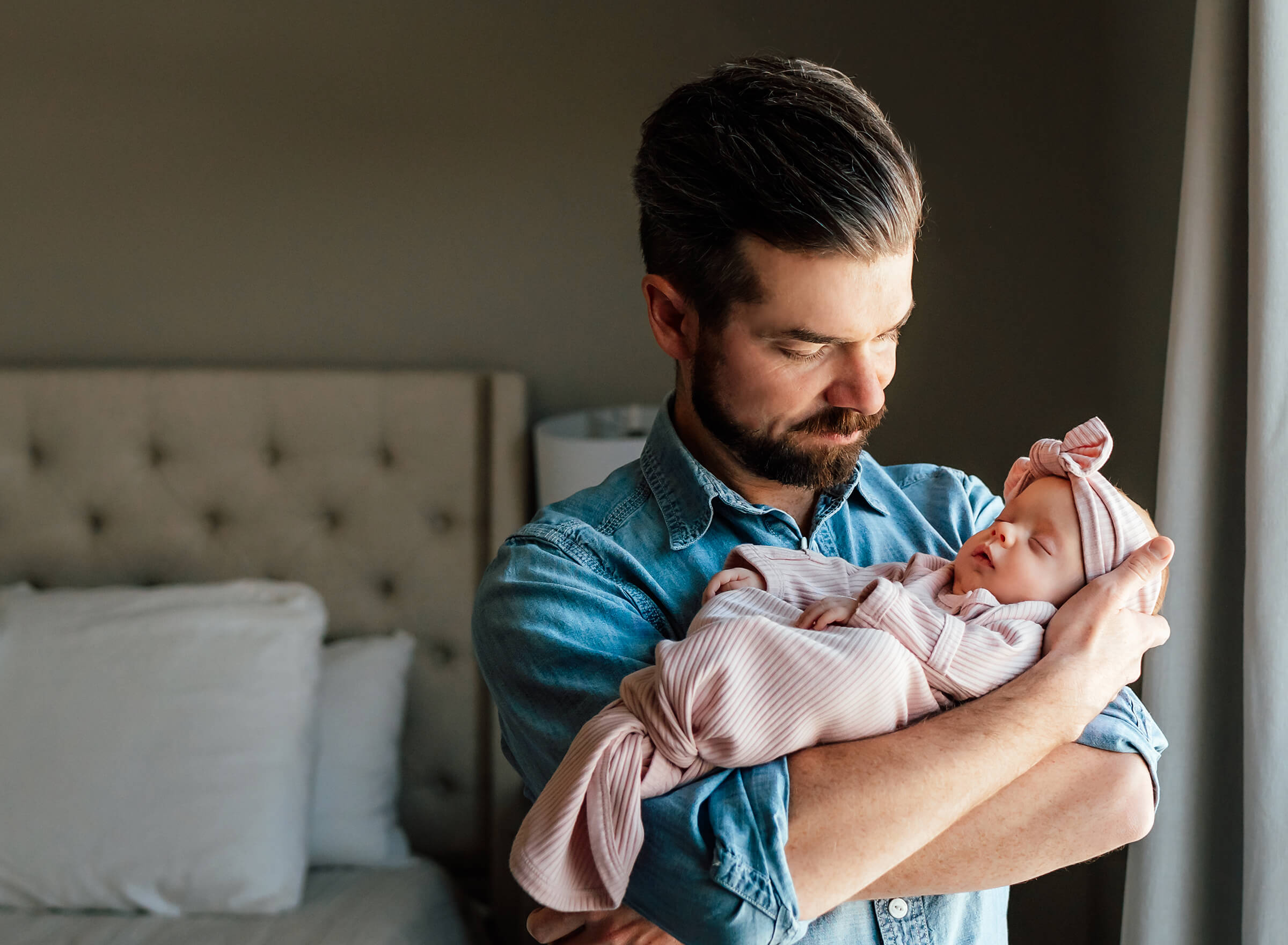 dad with his newborn daughter using natural window light