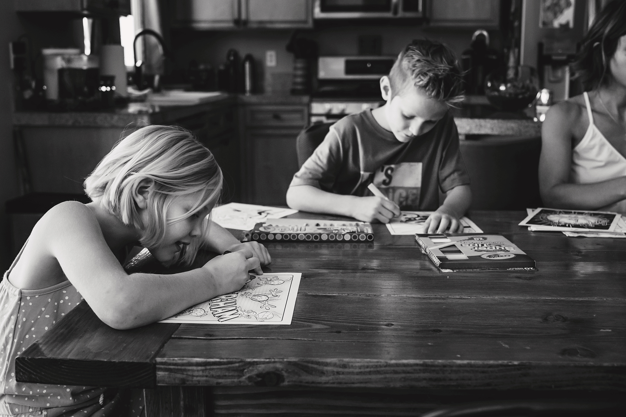 brother and sister coloring together at kitchen table