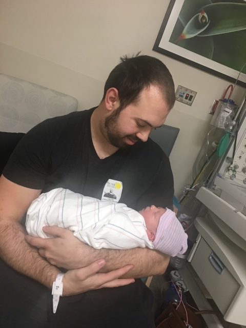 proud father holding his new son after delivery in the hospital
