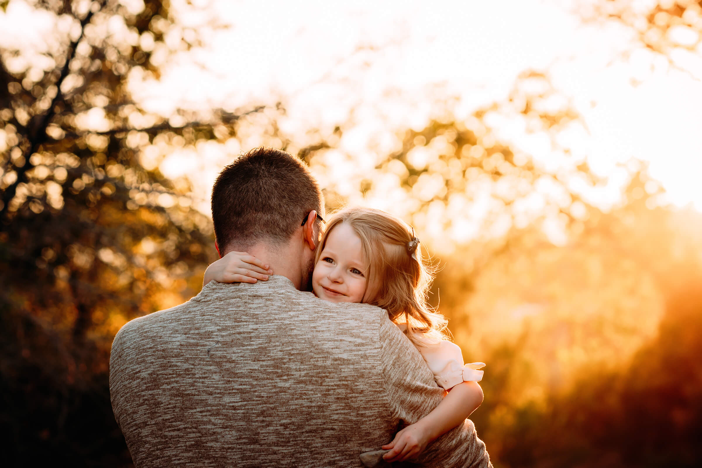 dad holding his daughter during beautiful fall family session 