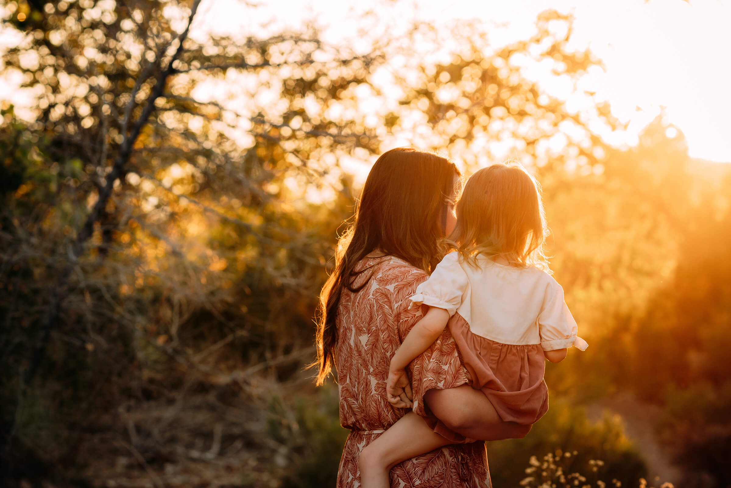 mom holding her daughter in beautiful golden light