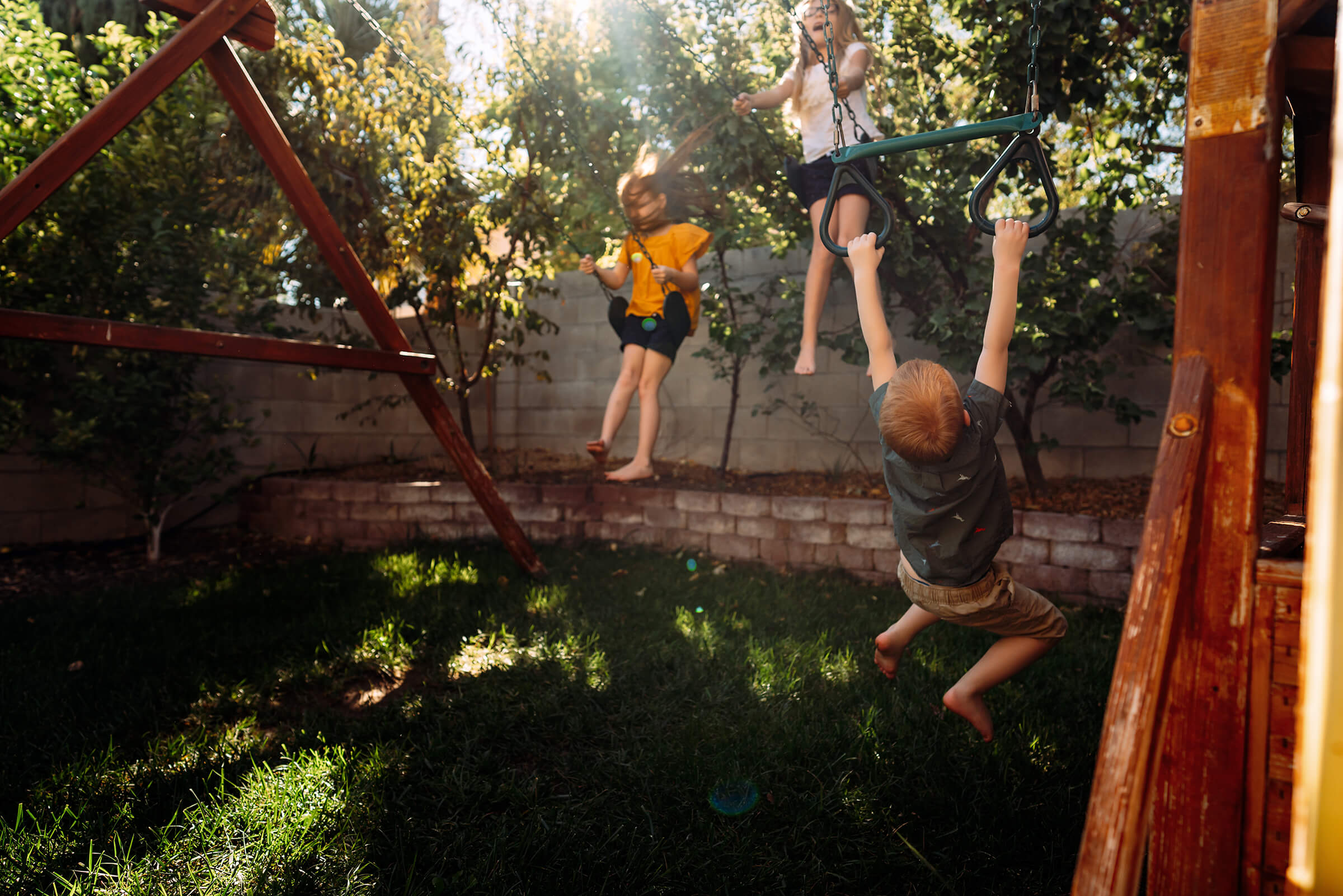 kids swinging in the backyard during a las vegas family session