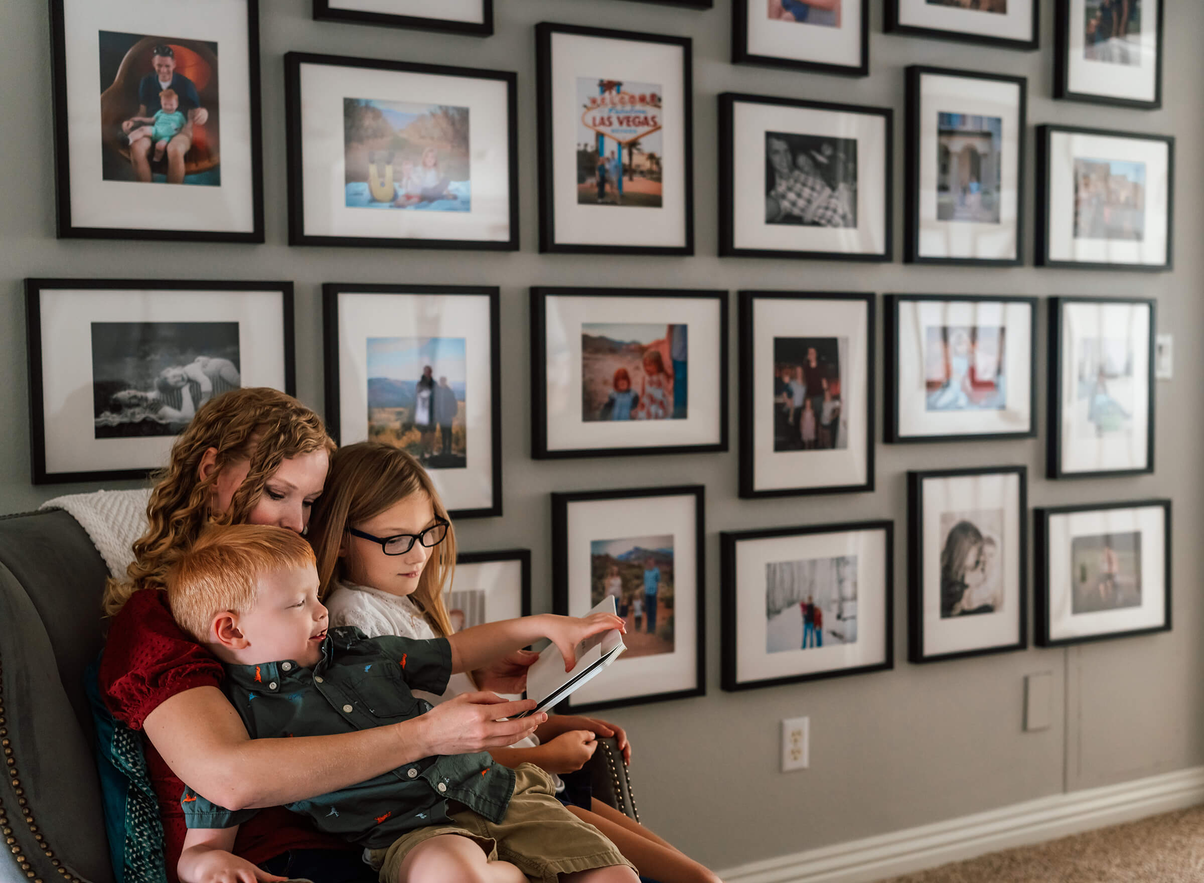 mother reading with her children in hallway surrounded by family images