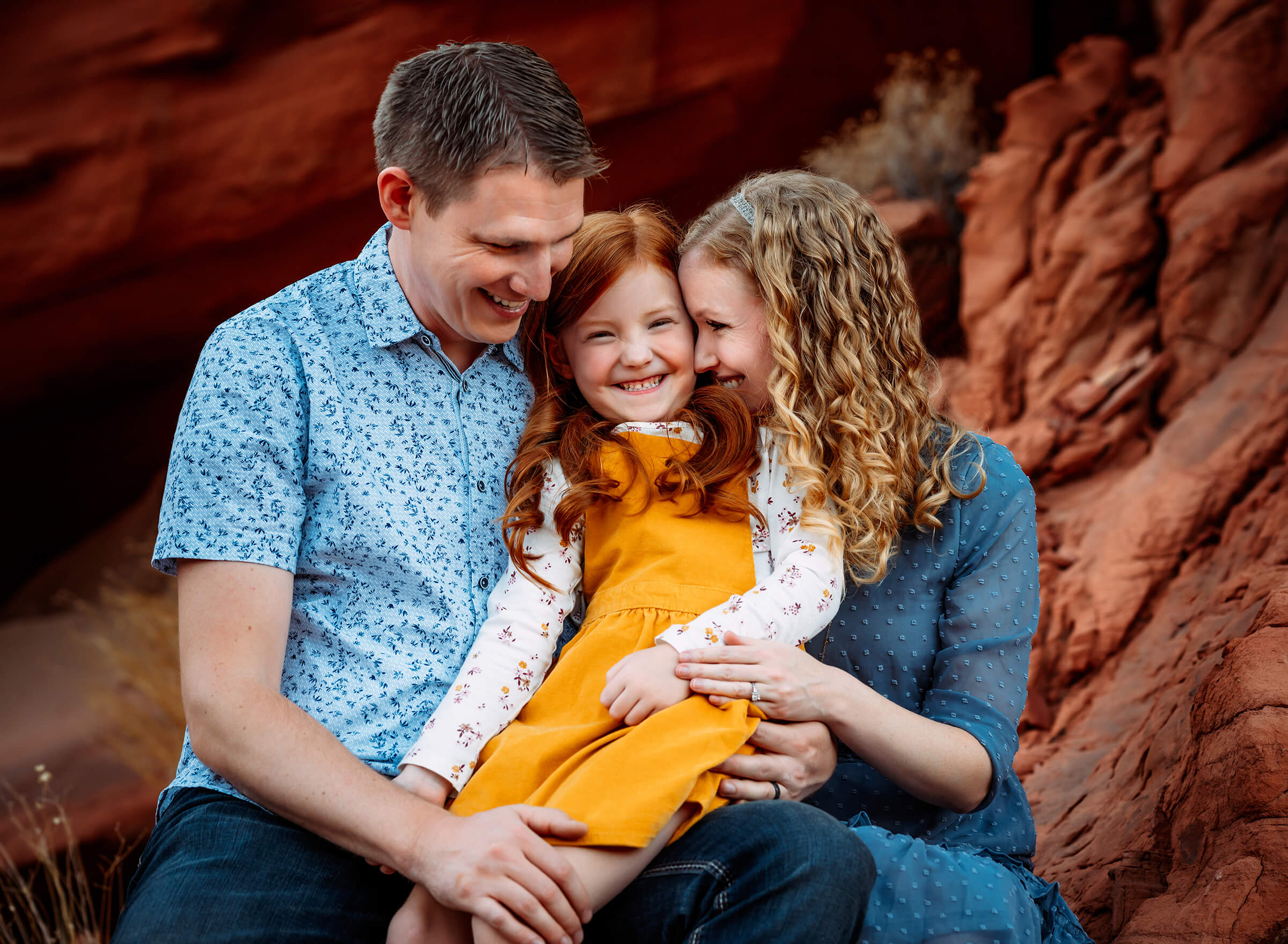 parents snuggling with daughter during family session las vegas