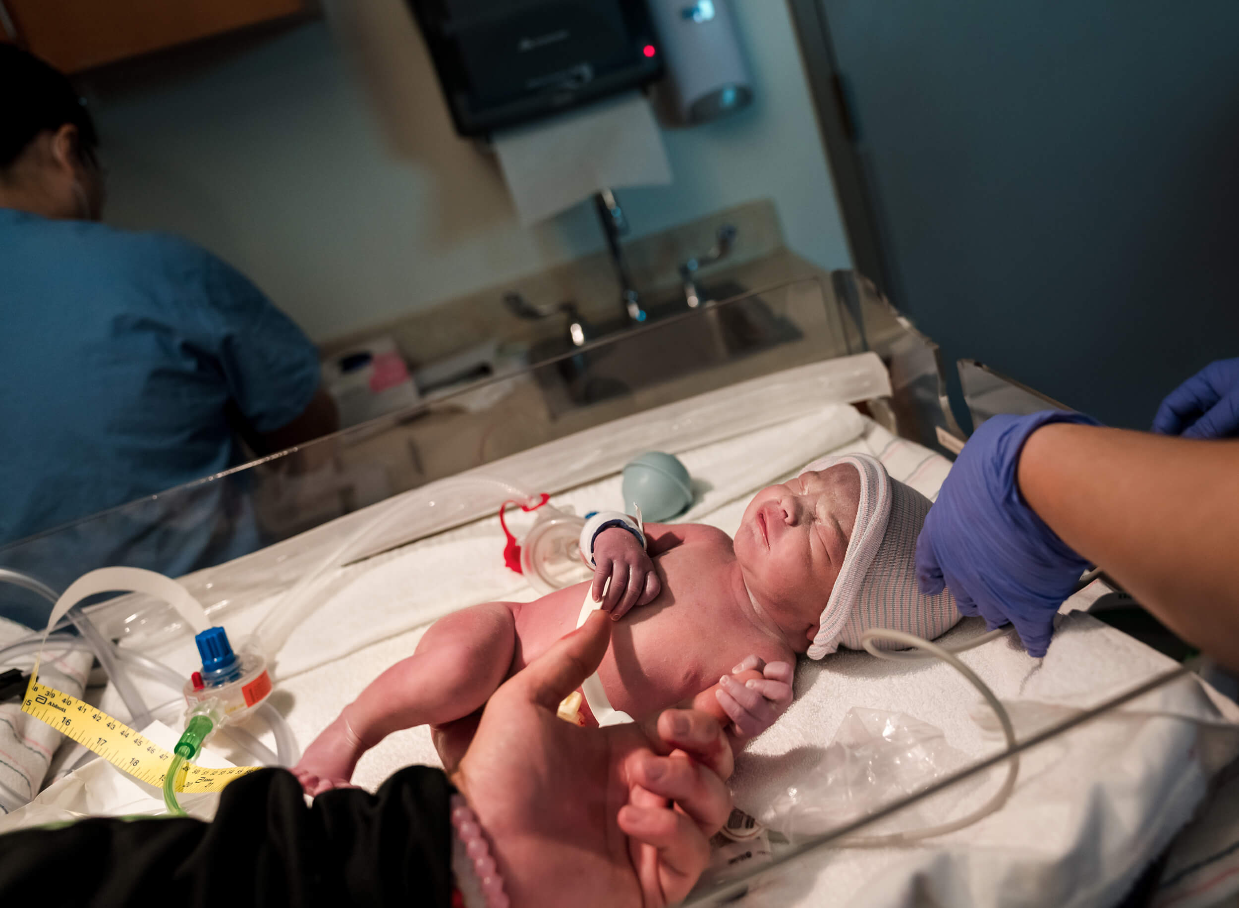 baby holding father's finger after birth