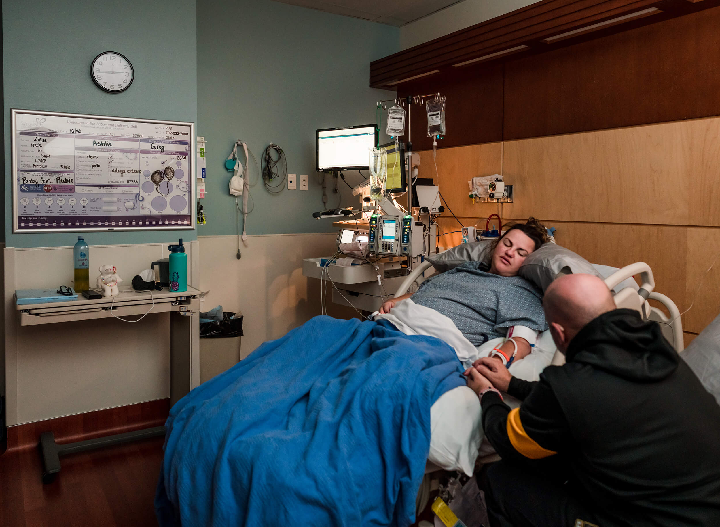 tender moments between husband and wife in hospital while wife labors