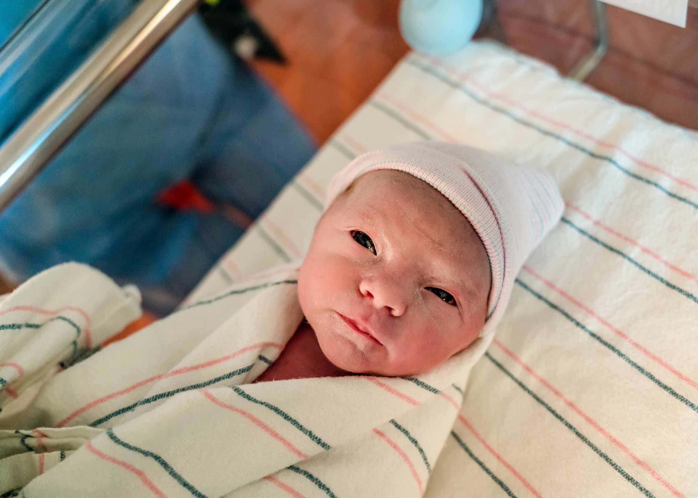 infant swaddled in bedside crib at the hospital
