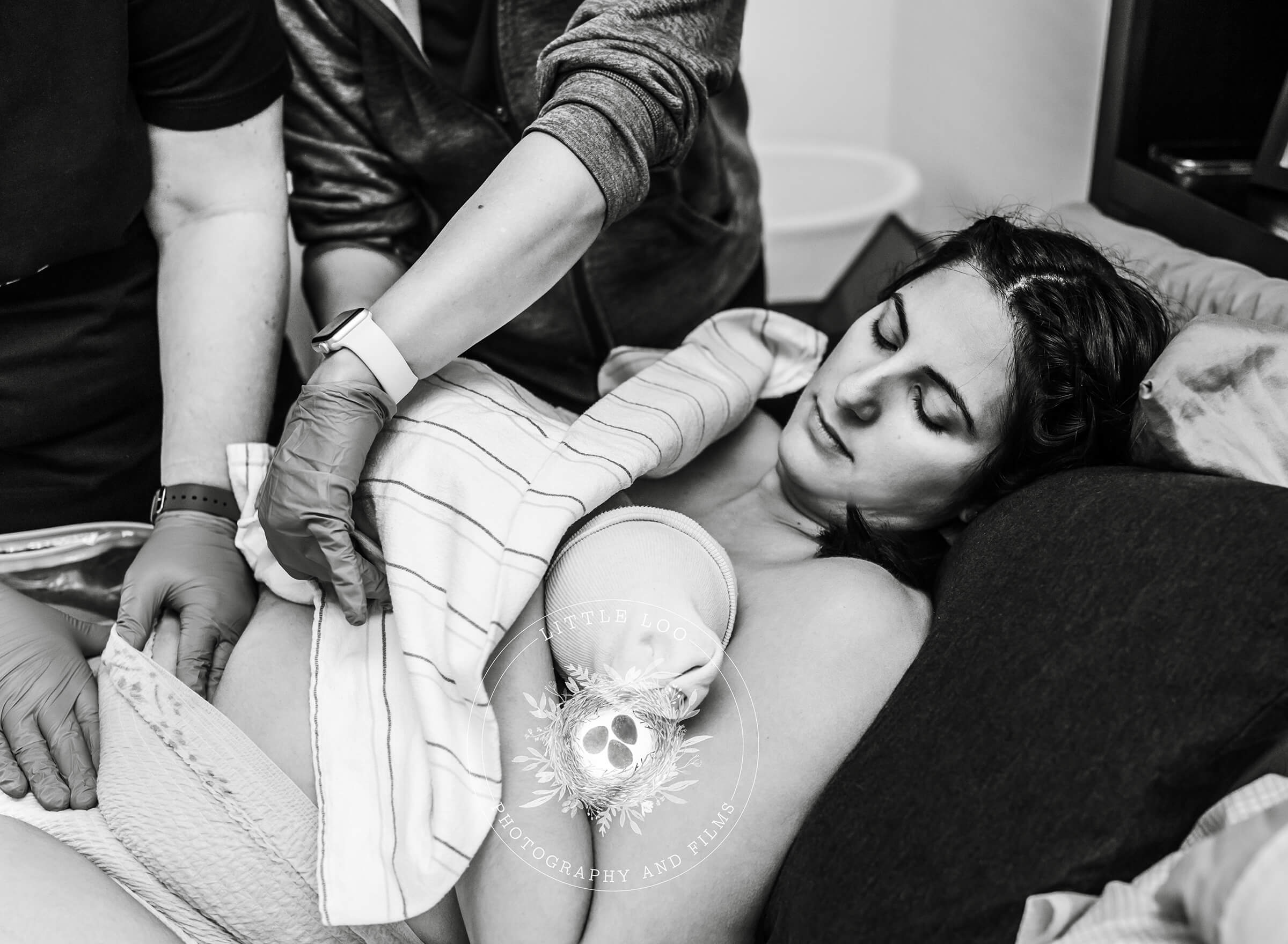 mother holding her baby while her fundus is massaged