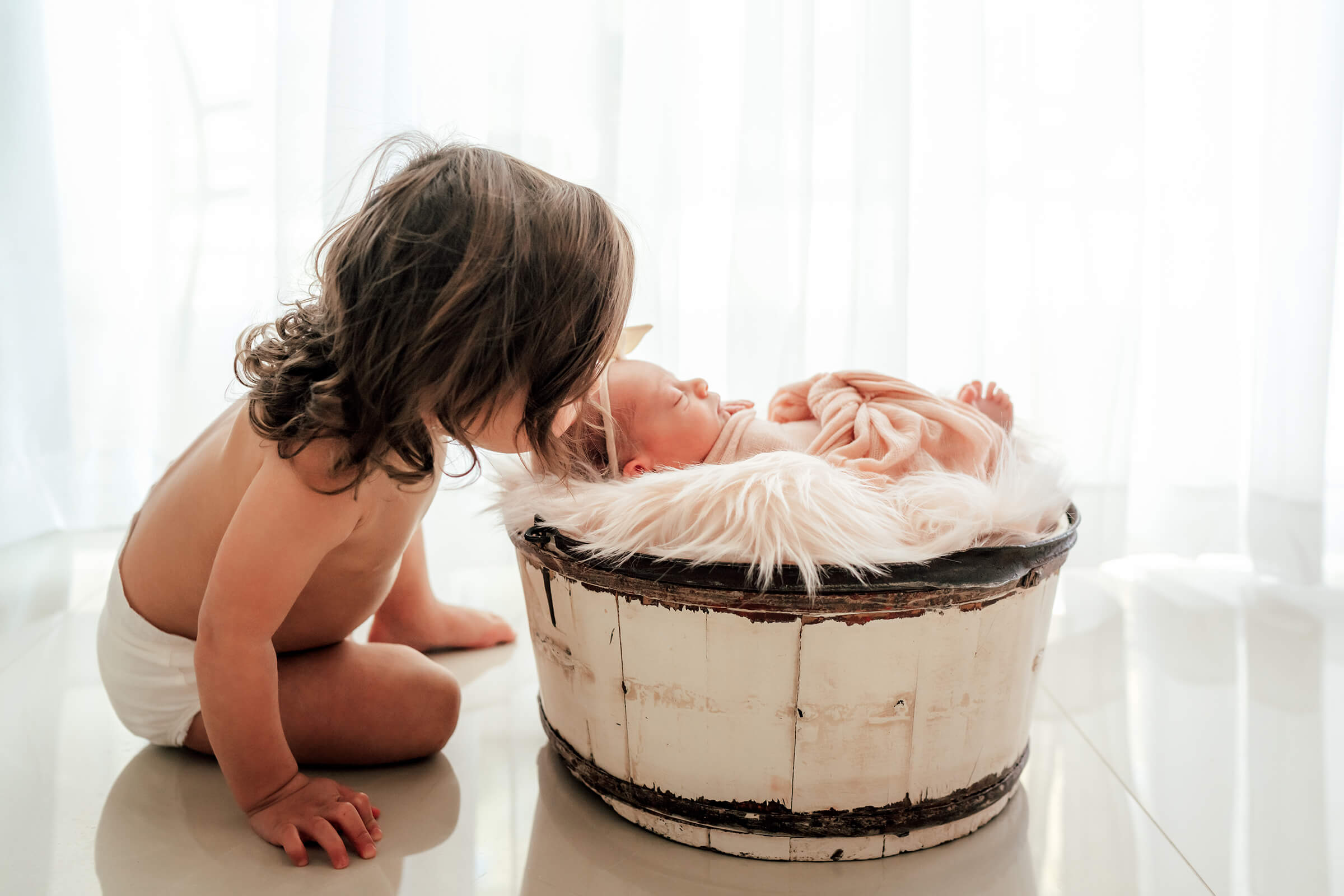 sister kissing her little sister on the head. 