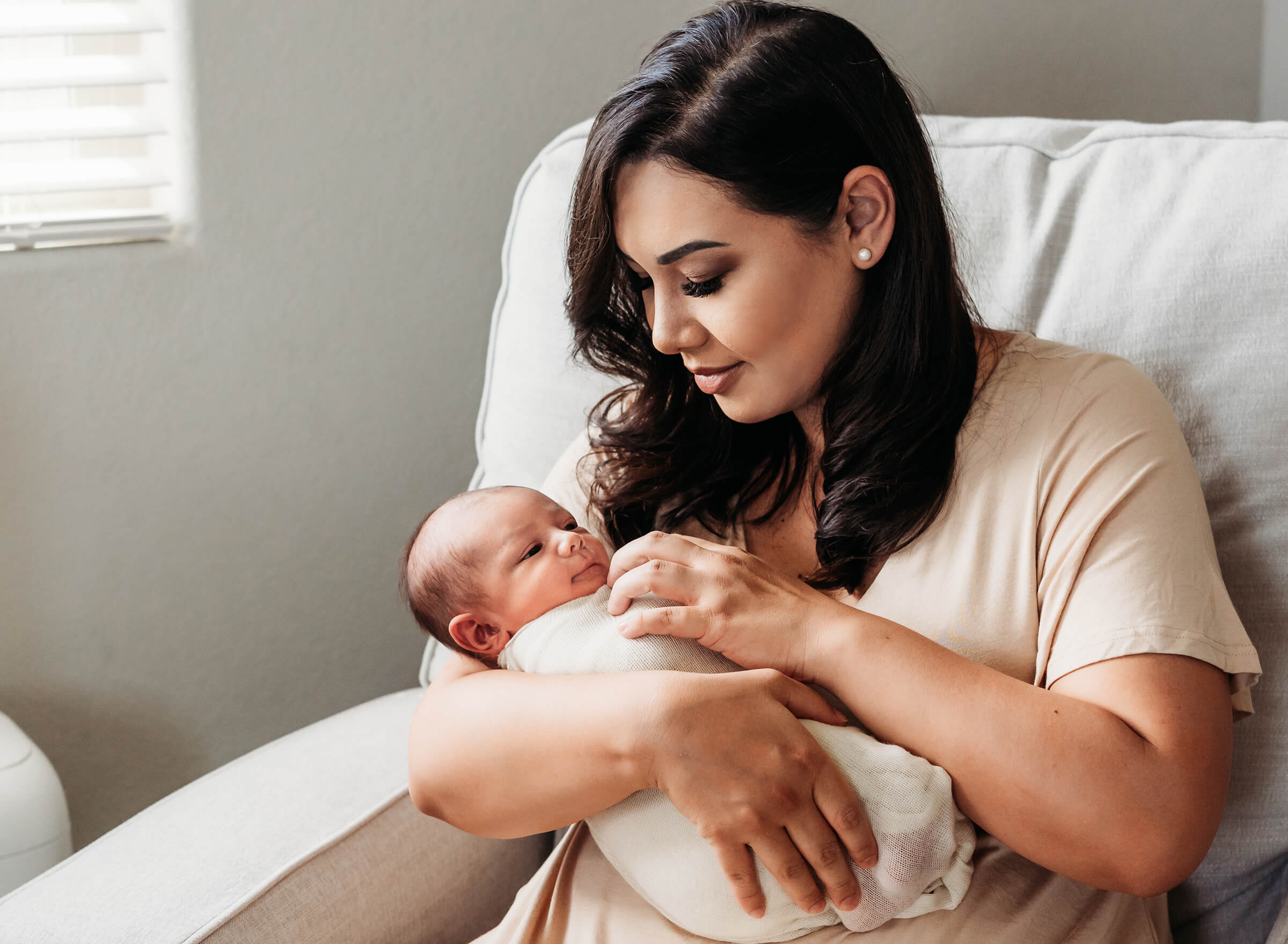 mother holding her son in rocker newborn session 