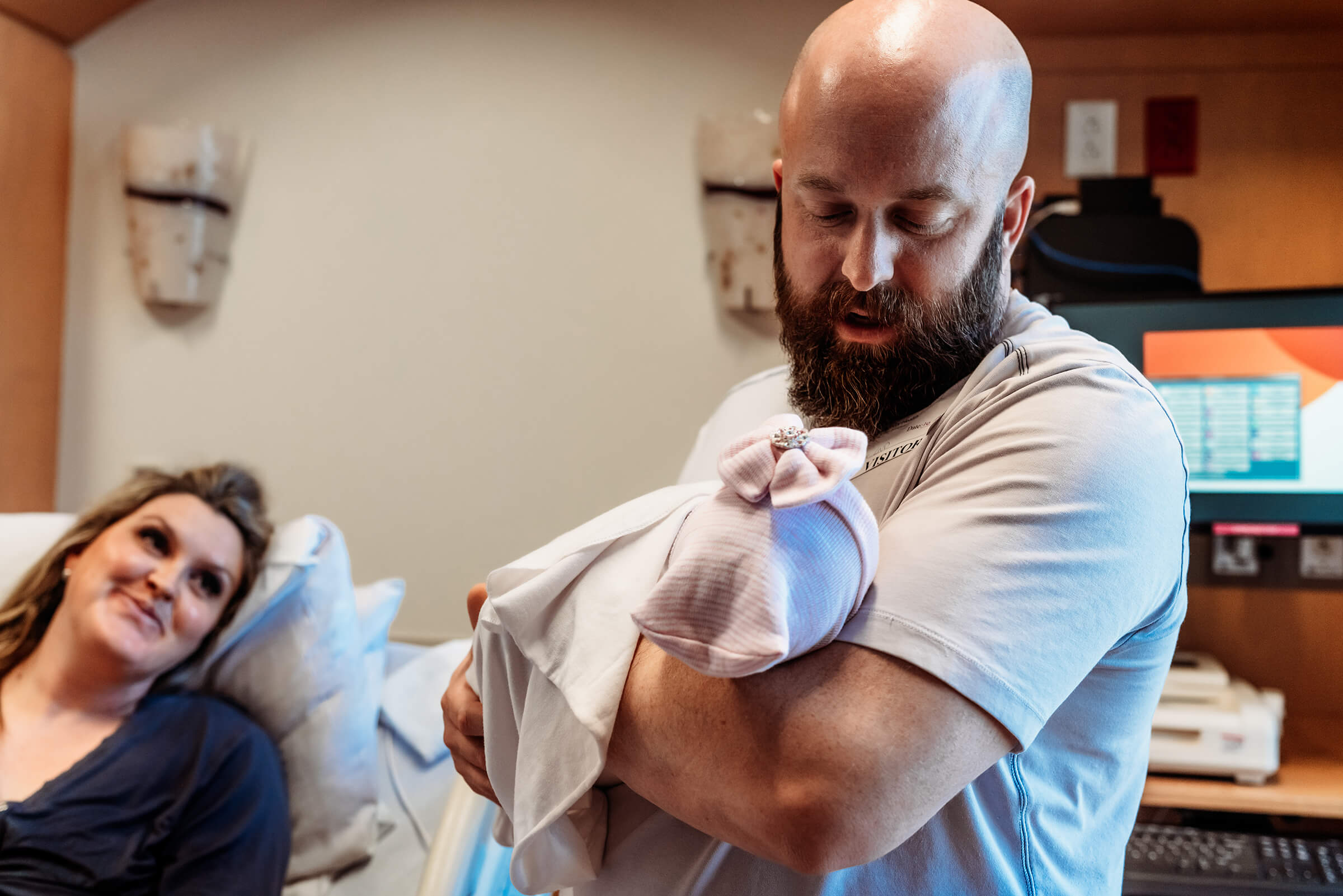dad holding his new daughter after delivery