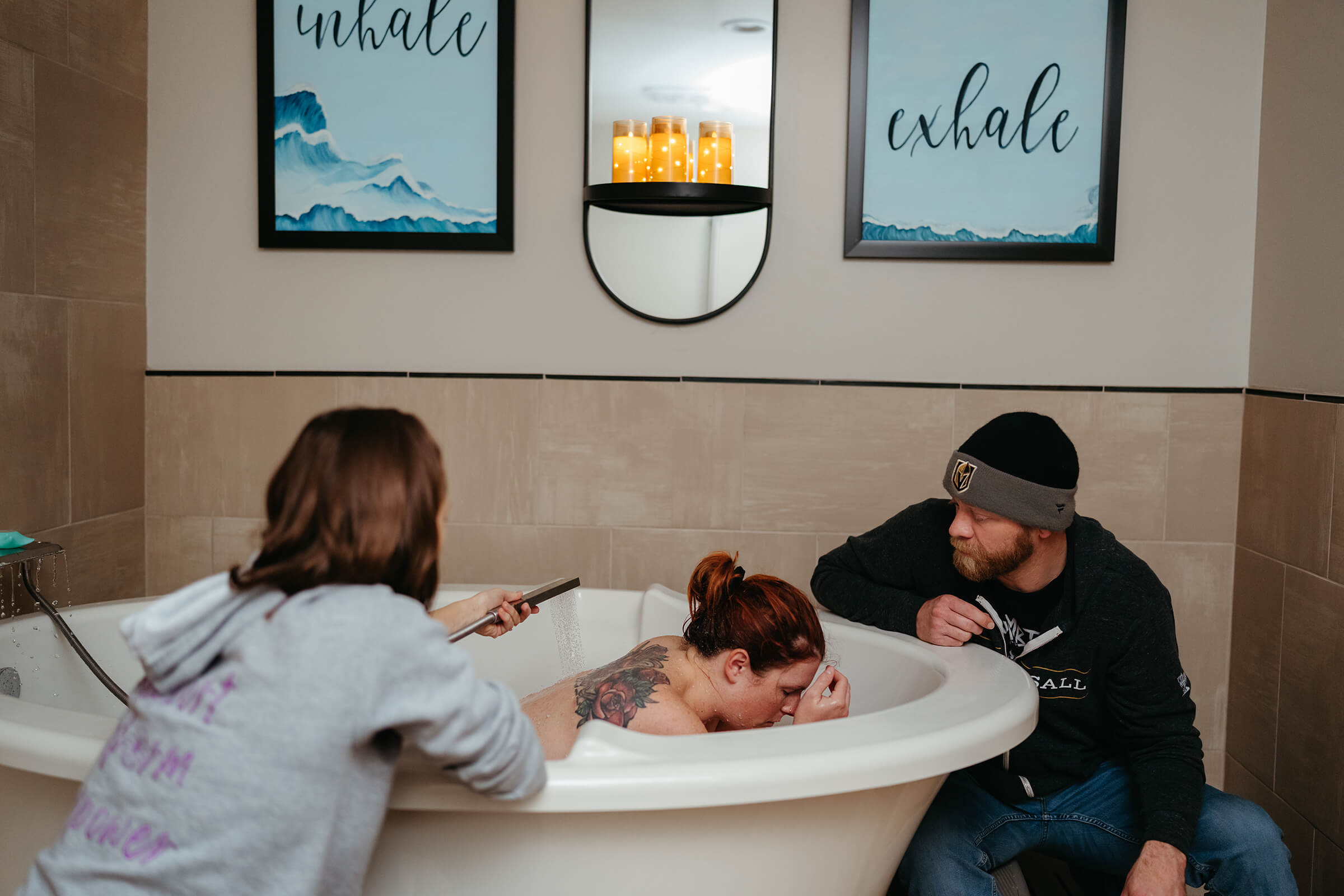 mother laboring in tub at Serenity Birth Center in Las Vegas with husband and doula at her side. 