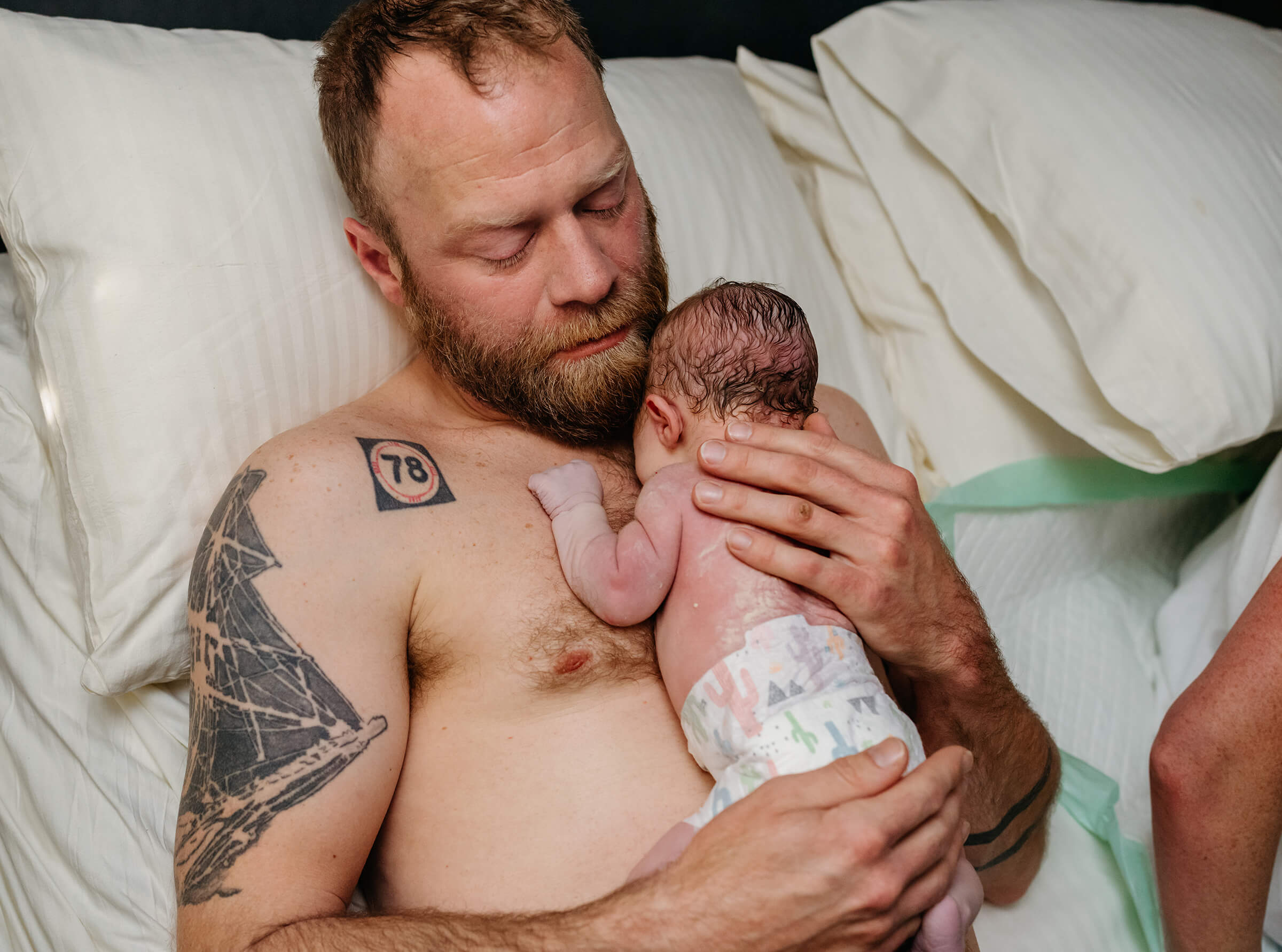 father enjoying skin to skin with his new baby while mother is cared for. 
