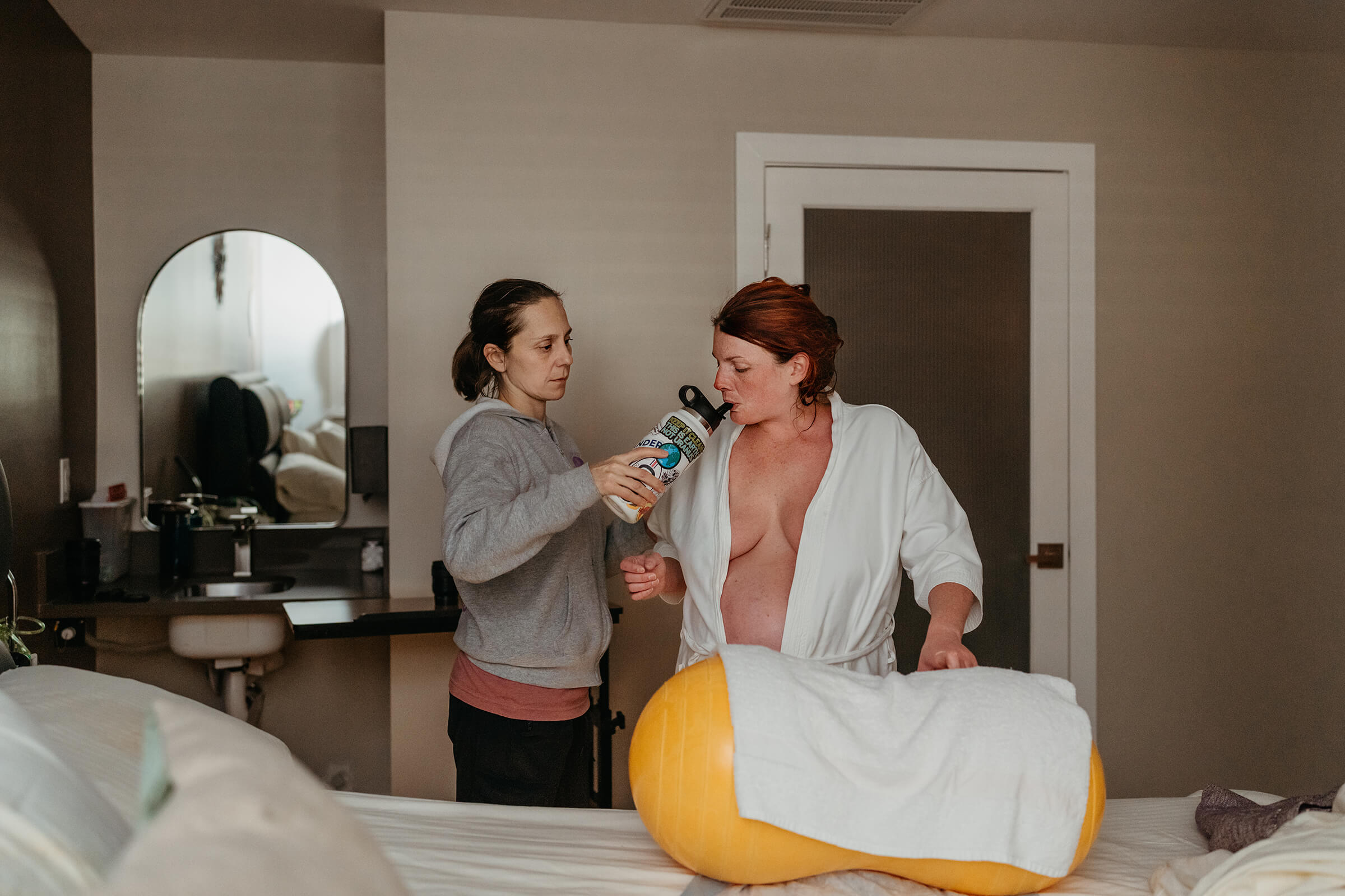 Las Vegas doula Regina Roy offering hydration to a mother laboring. 
