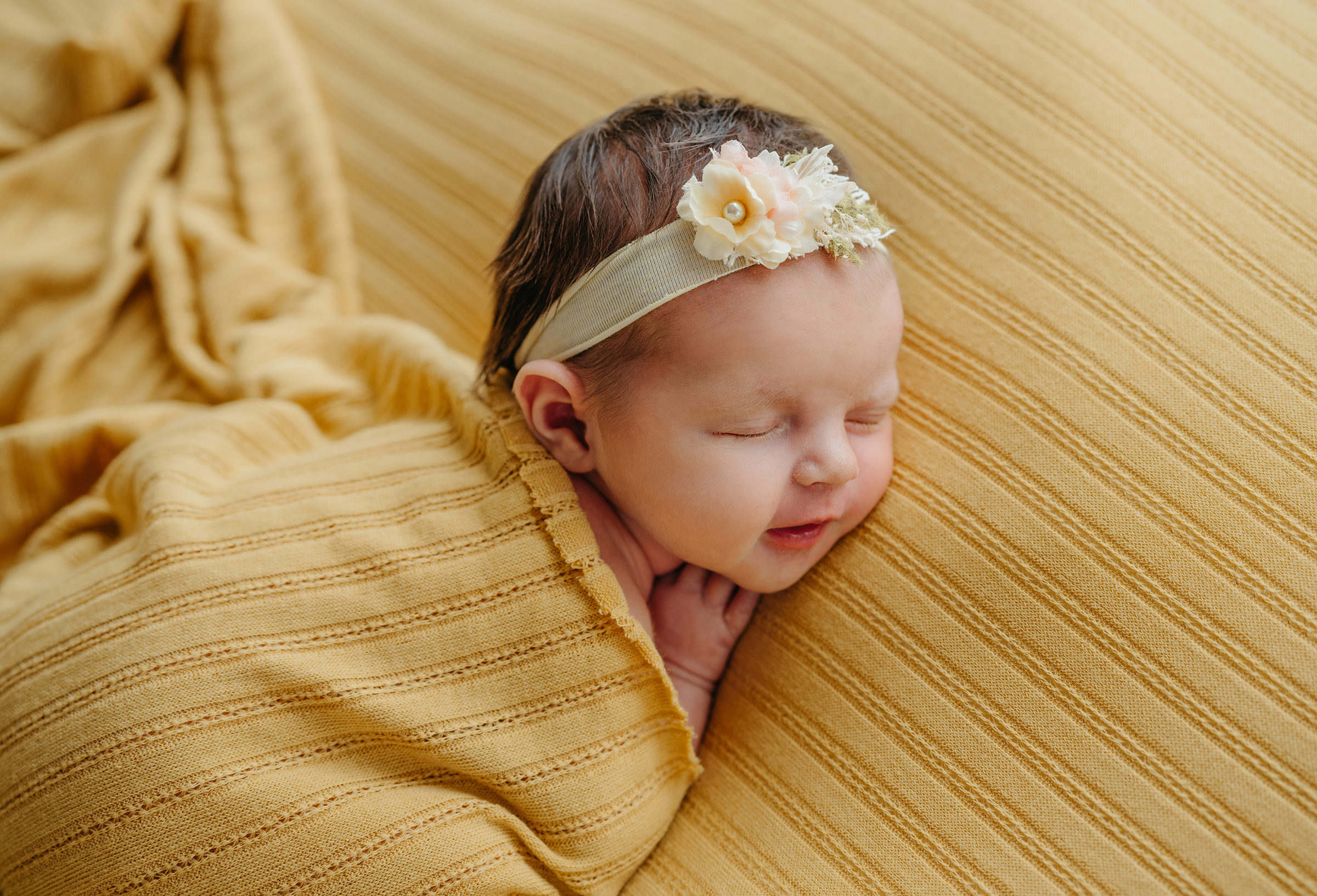 newborn session using yellow wrap and yellow drop