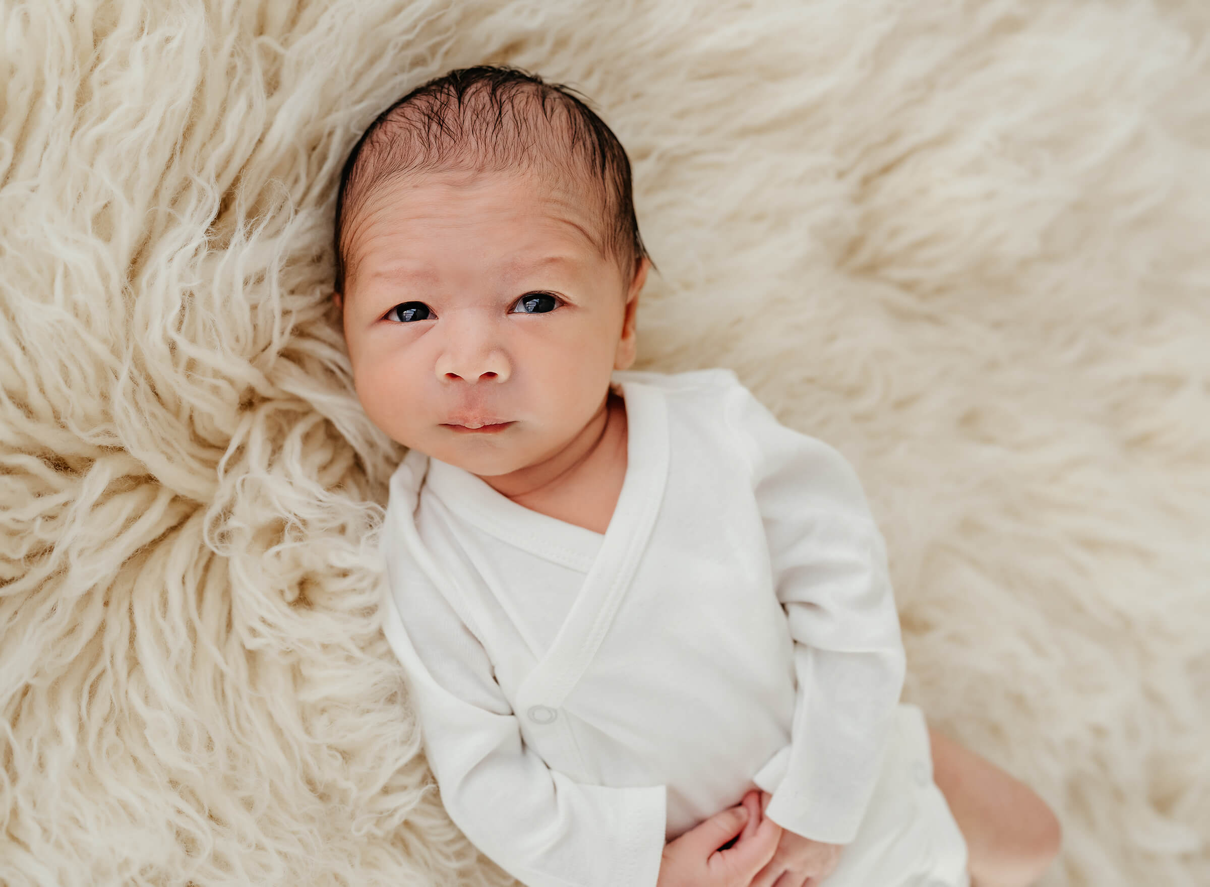 lifestyle newborn session with white onsie in Las Vegas