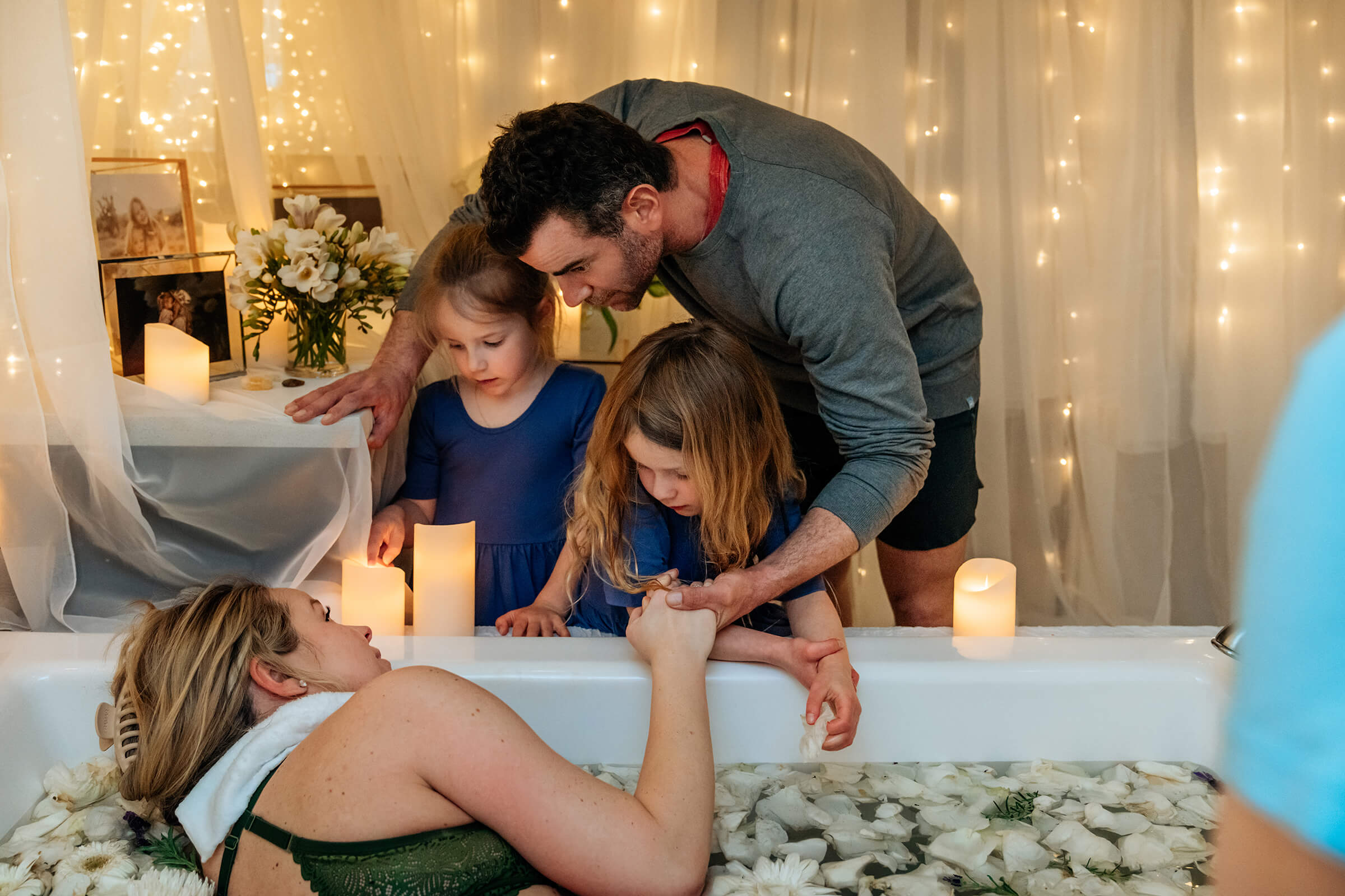 wife being supported by her husband and two daughters as she labors at home in her tub