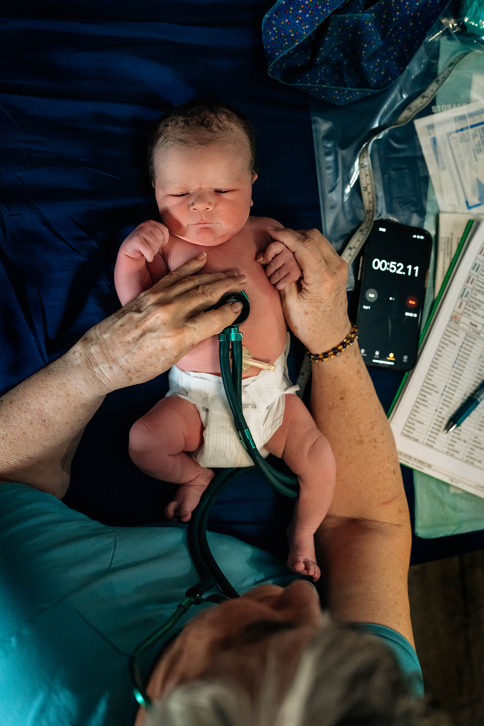 midwife checking baby's heart rate after a home birth 