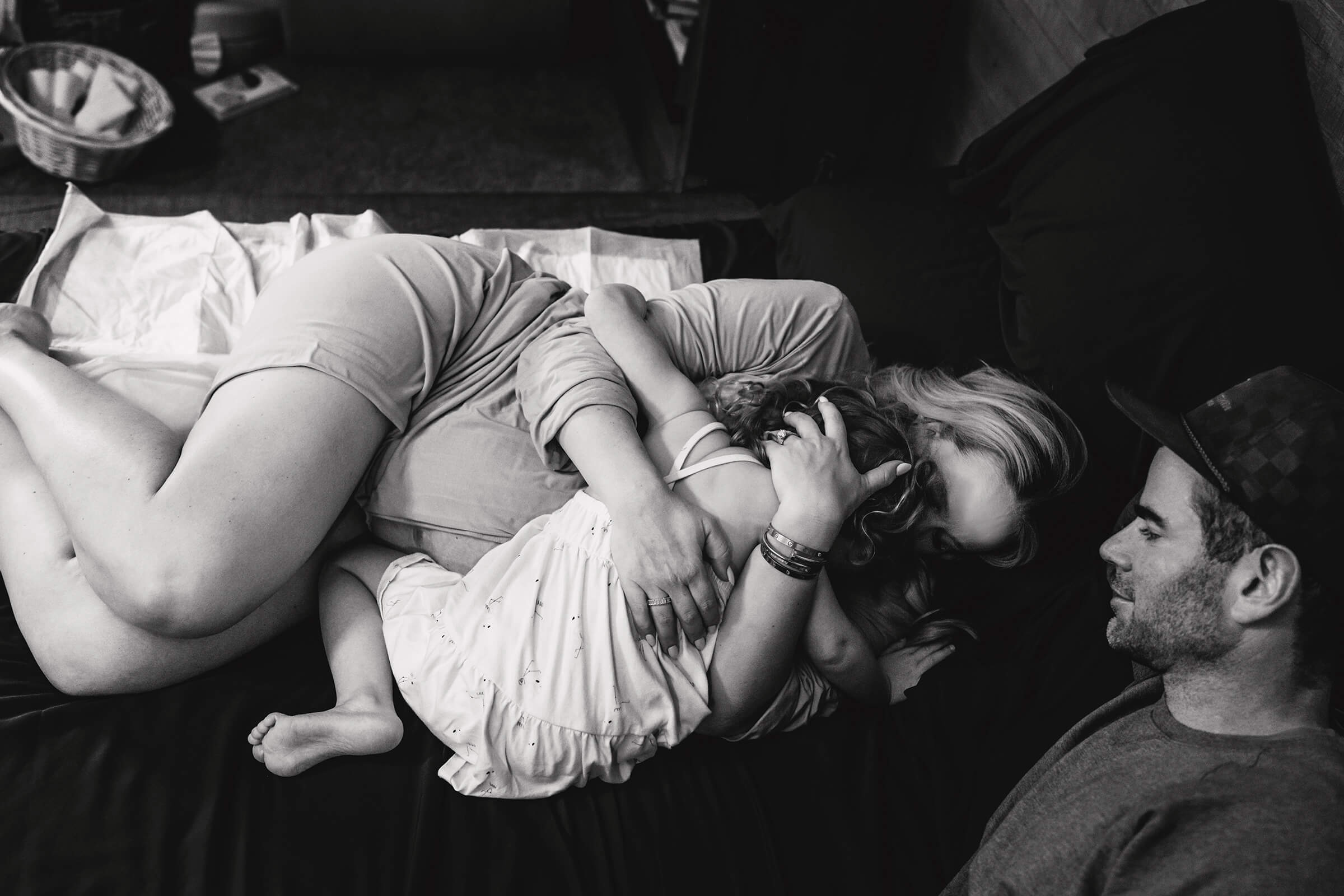 black and white images of mother holding her daughter in her arms at home