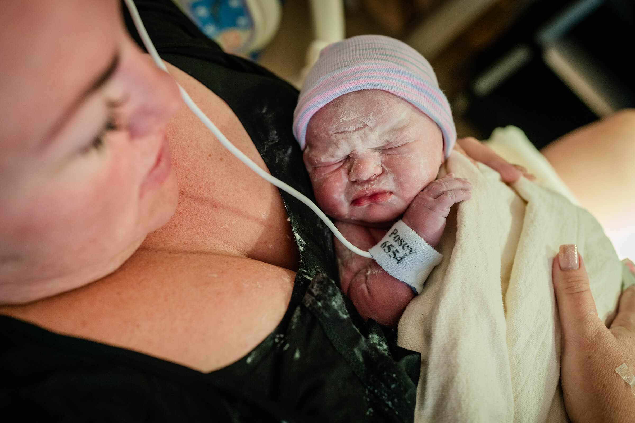 newborn baby girl in her mother's arms after a hospital delivery