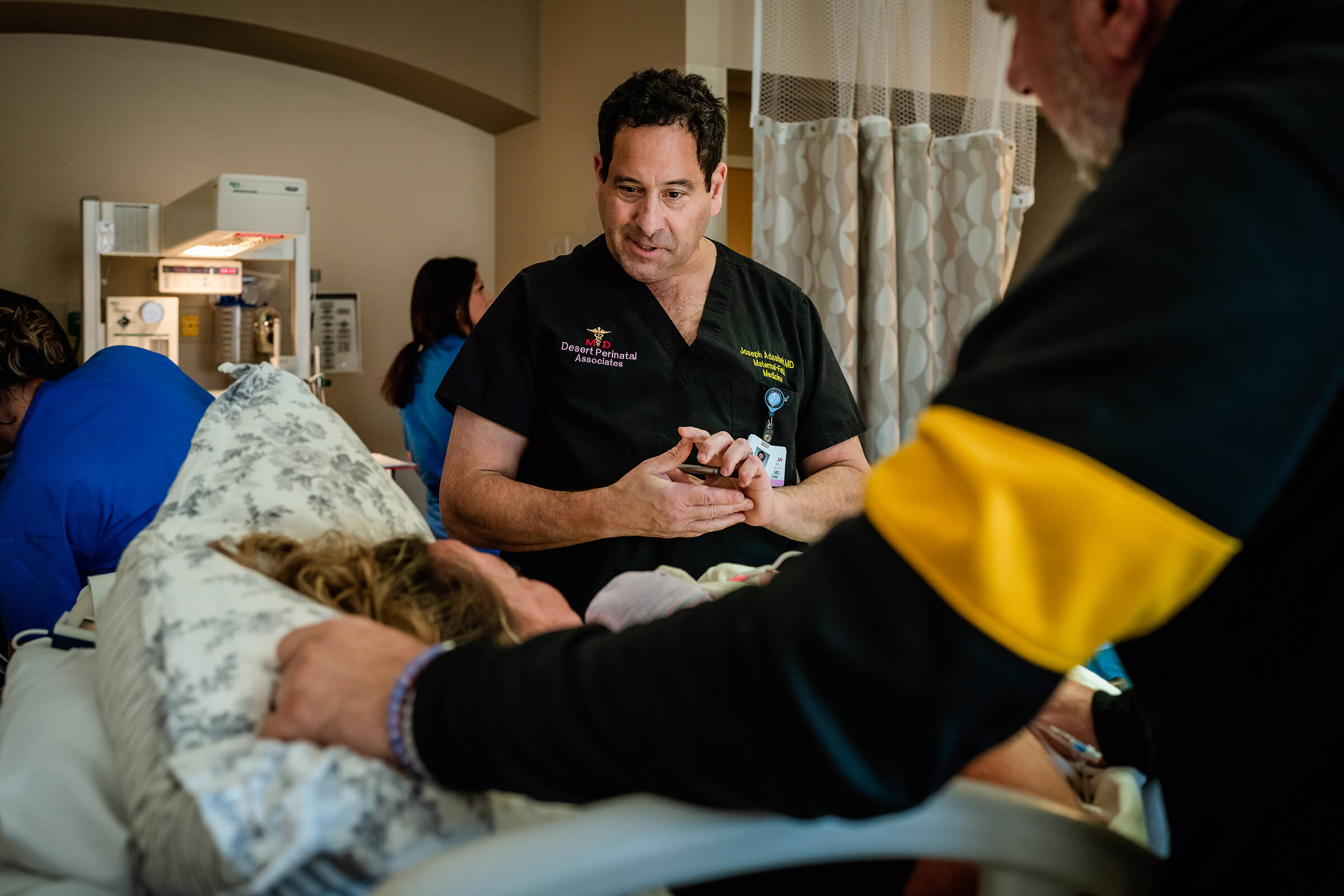 Dr Adashek at a patient's bedside after he delivered her baby