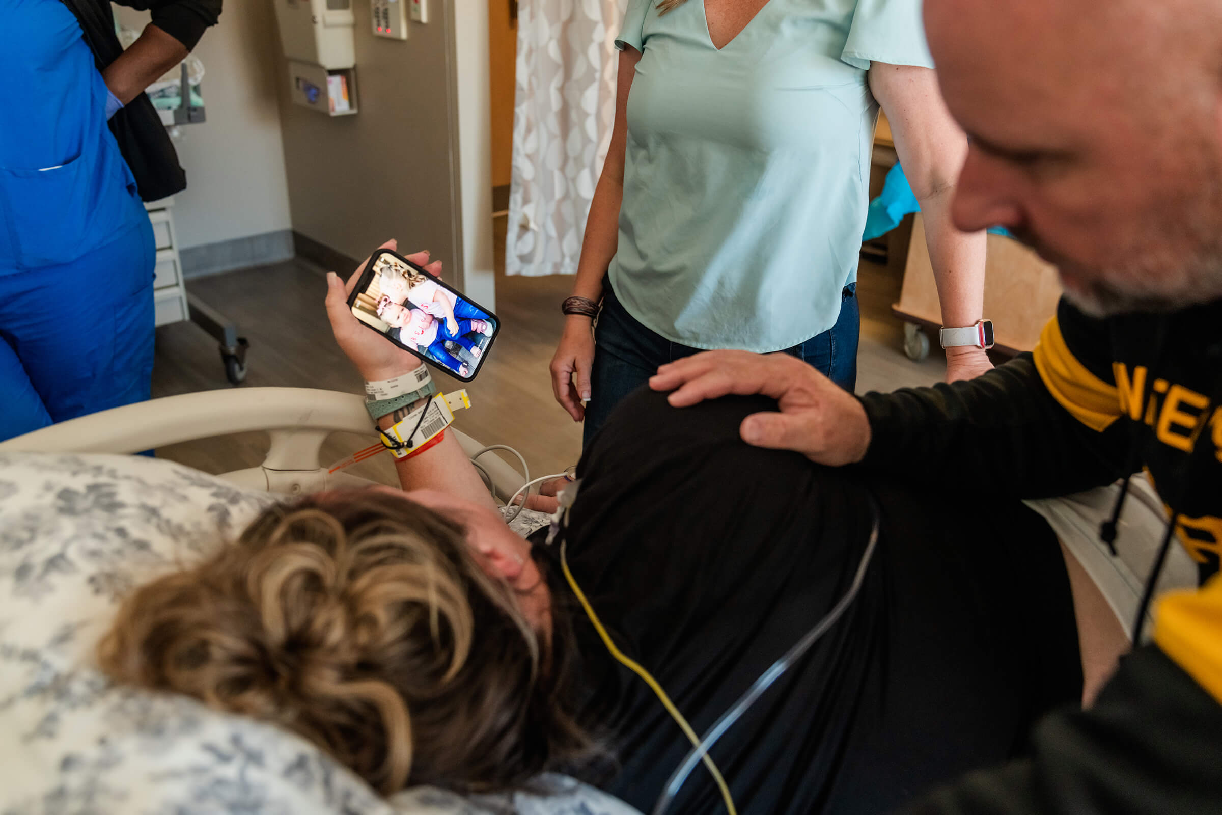 mother looking at a picture of her children for inspiration while in the hospital for delivery