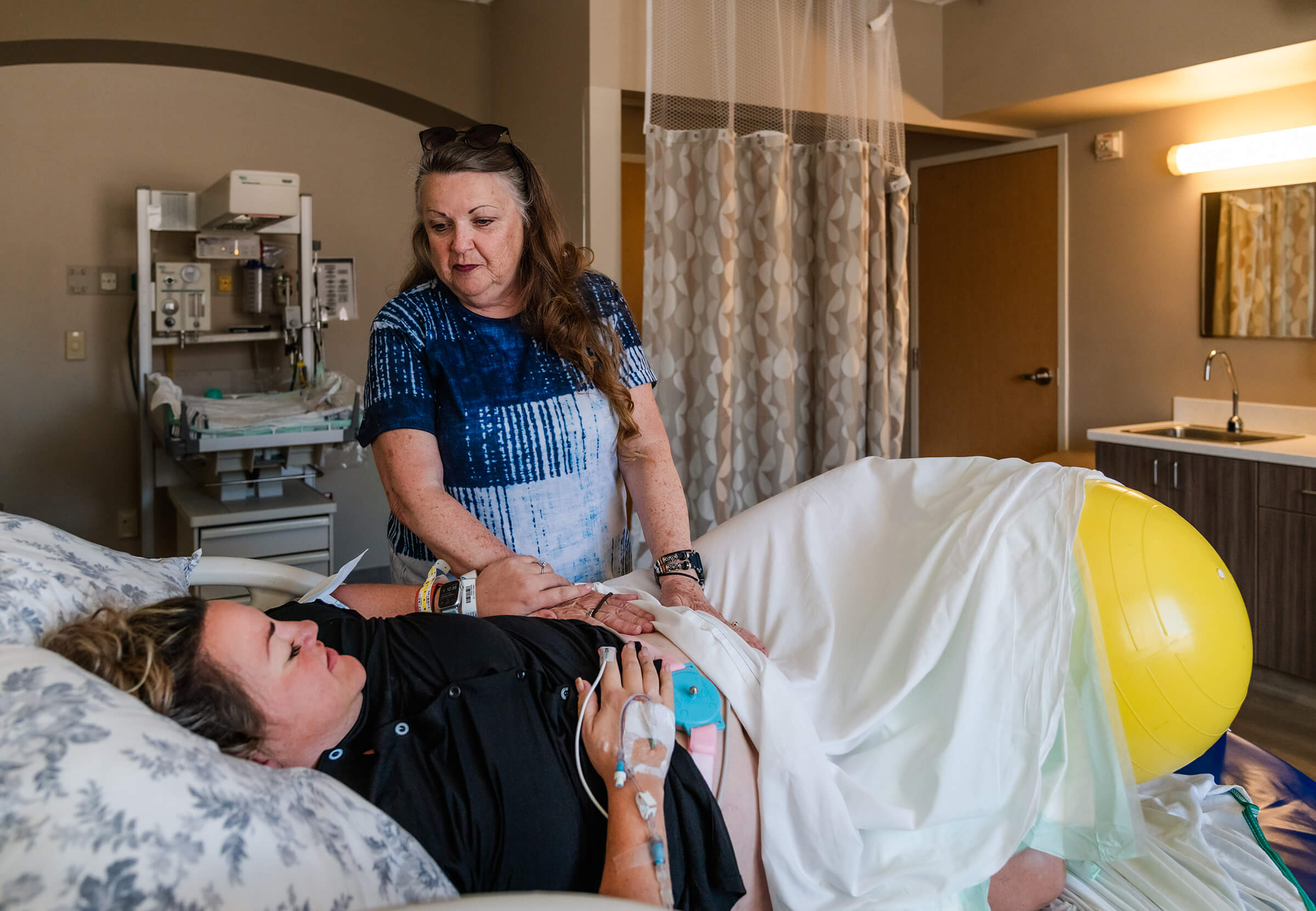 a mother supporting her daughter while in labor through words of encouragement and physical touch