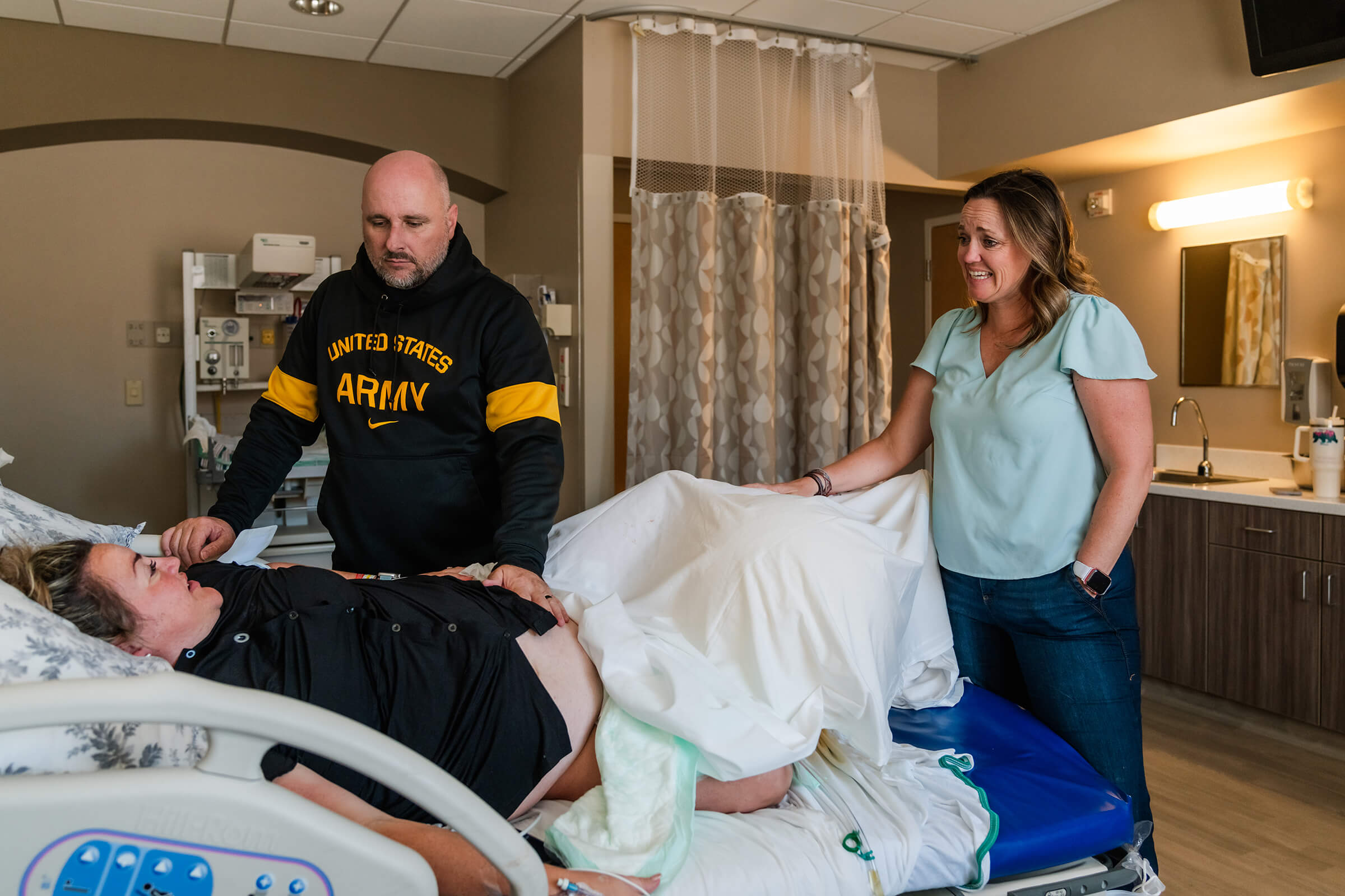 a mother being supported by her sister and husband while laboring in a hospital bed in Las Vegas