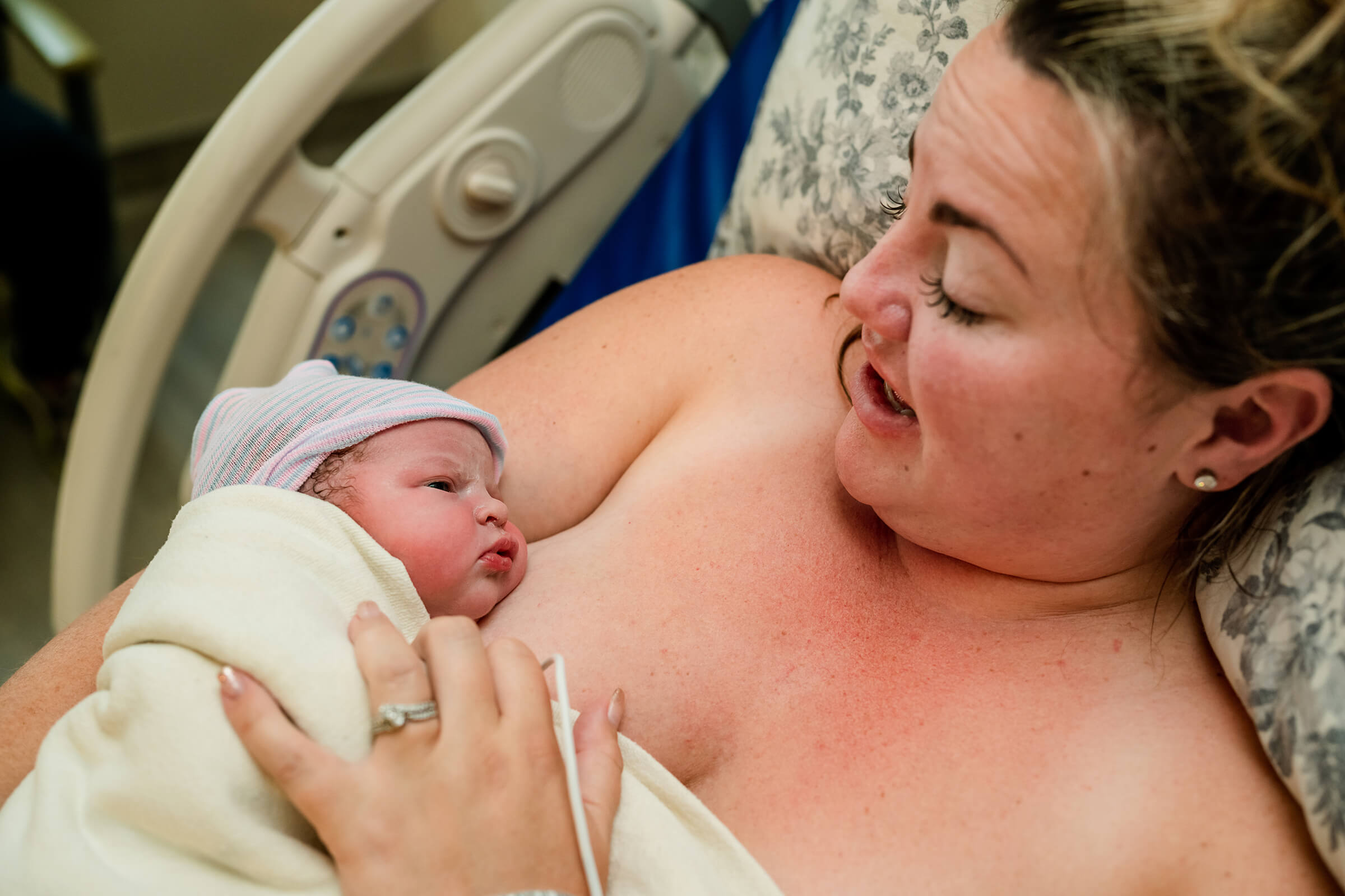 mother holding her newborn daughter skin-to-skin his her hospital bed