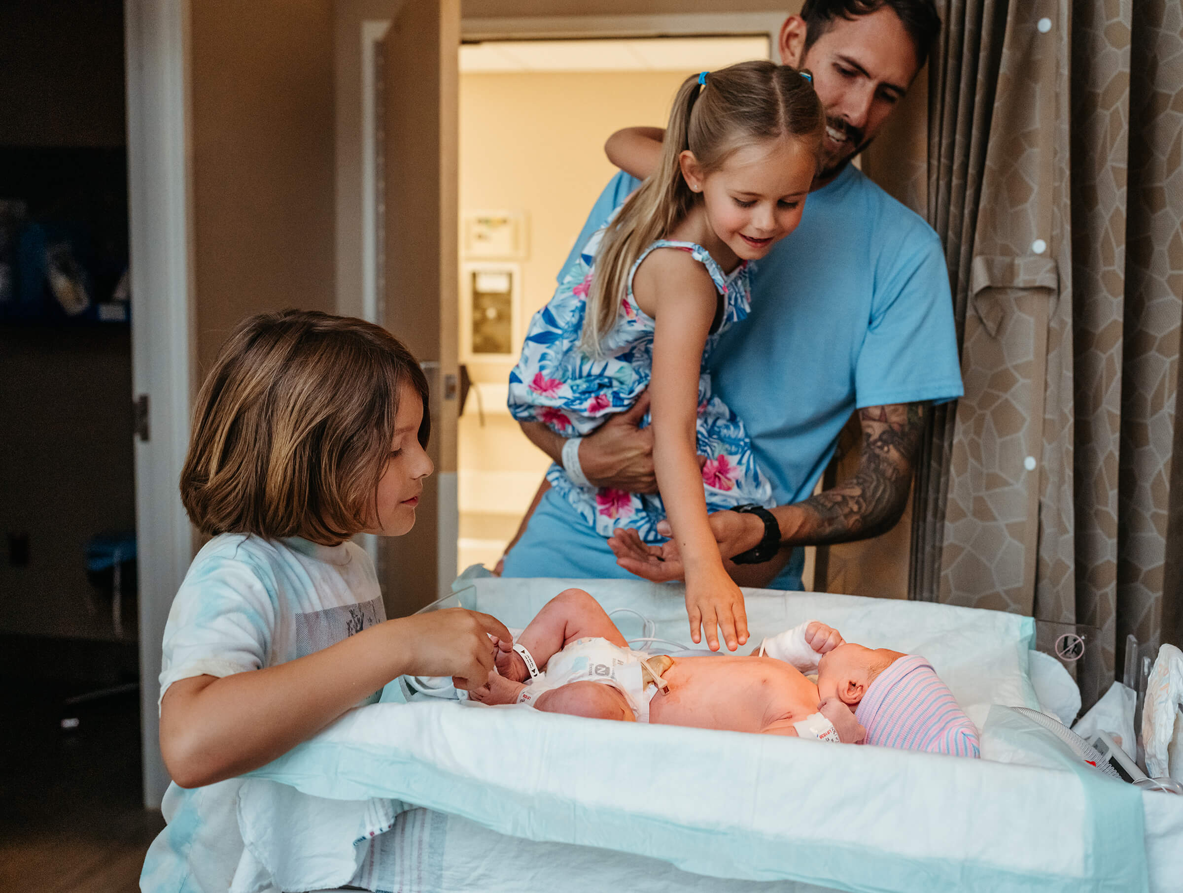 new brother and sister meeting their new baby brother for the first time after hospital delivery