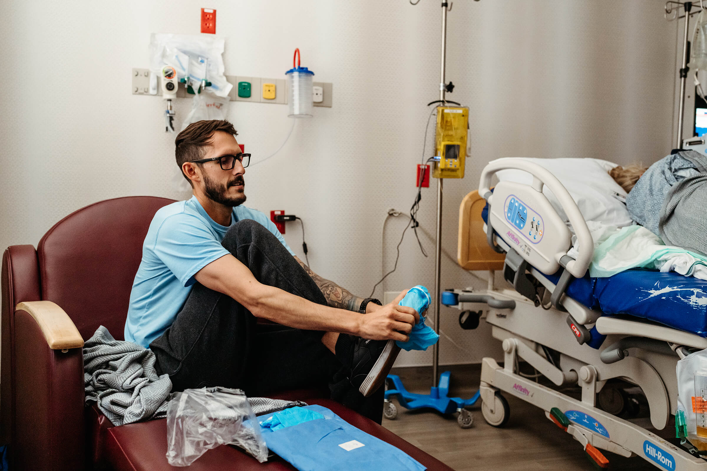 dad putting on shoe covers before going back to the operating room with his wife after decision for cesarean 