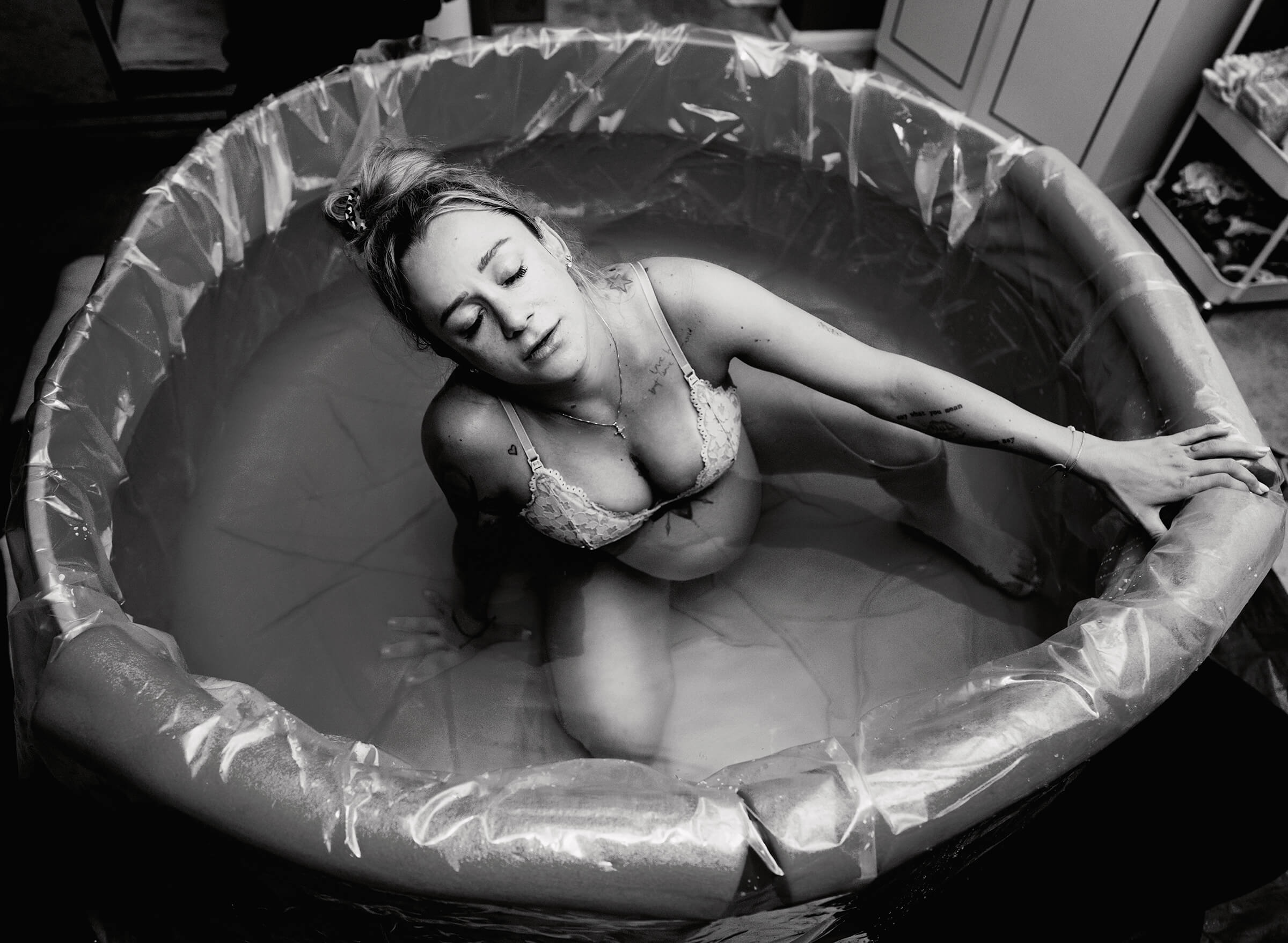 black and white image of woman laboring in water at home