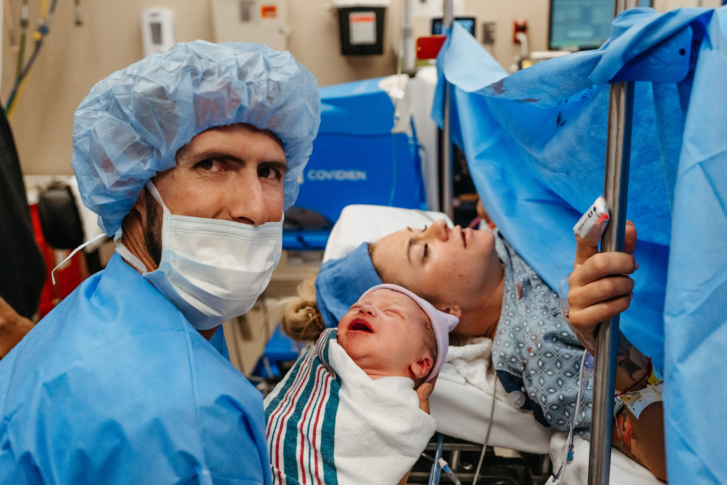 image of parents together with their new baby in the operating room after a c-section