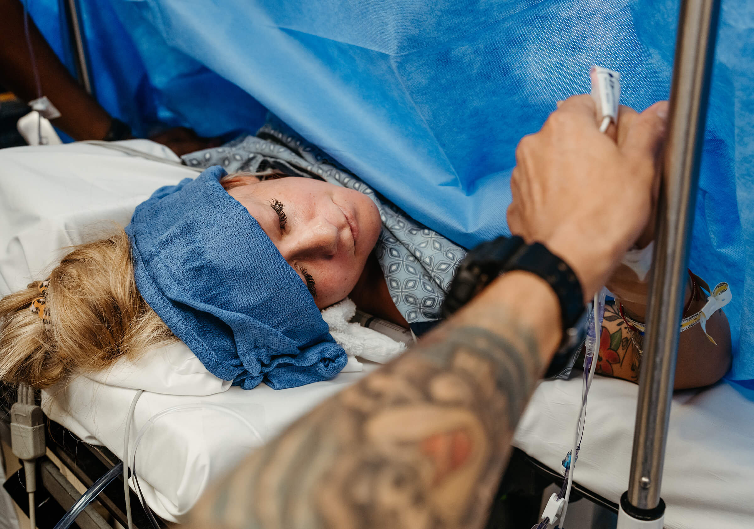 husband holding his wife's hand during a c-section 