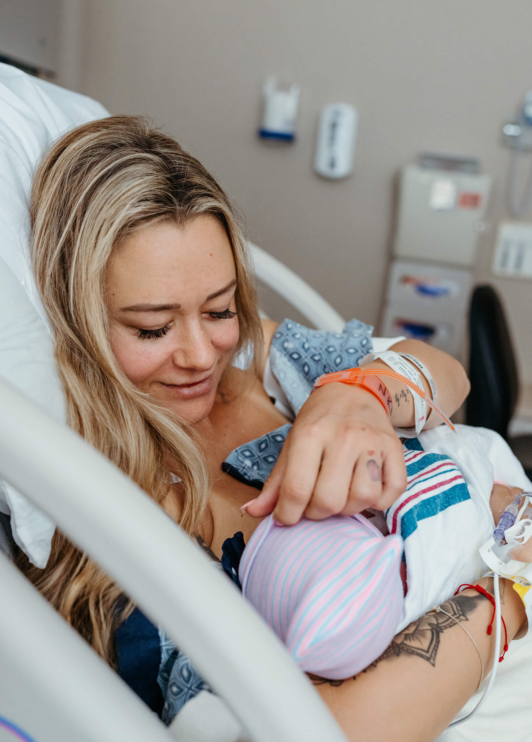 new mother lifting her newborn's hat so she can see it's hair