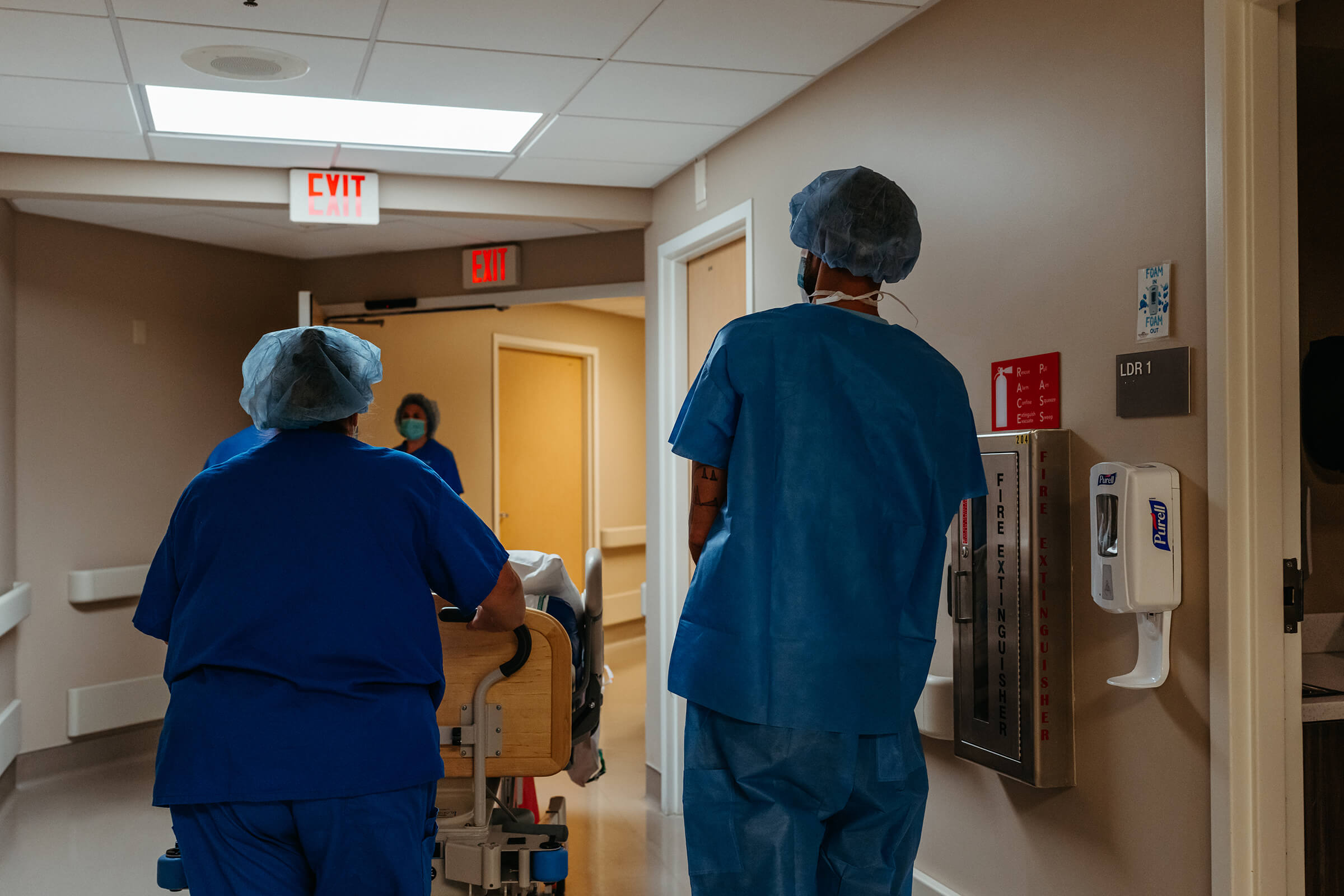 mother being moved back to the operating room via her bed in bed before a c-section