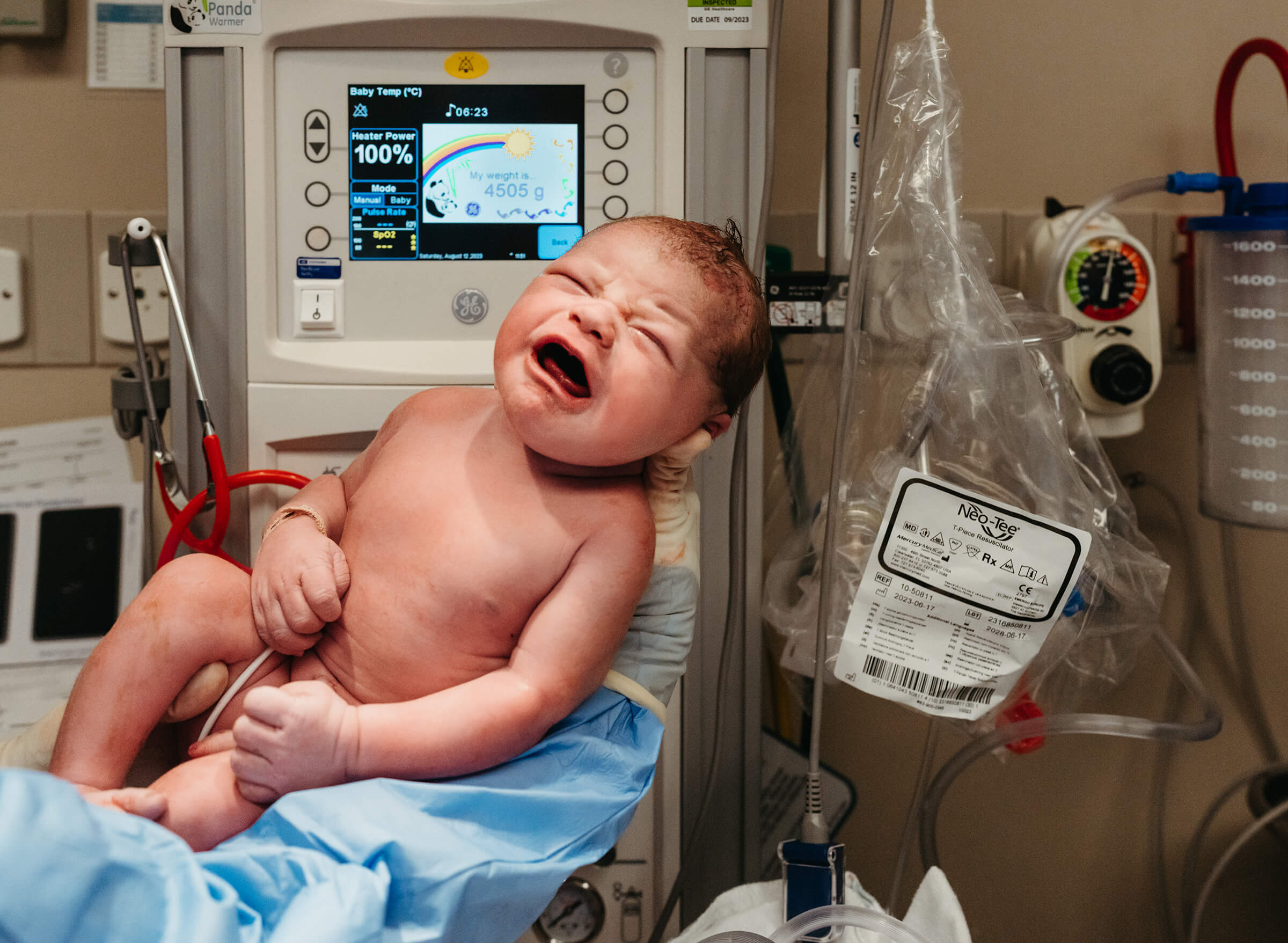 newborn being weighed in the operating room after delivery