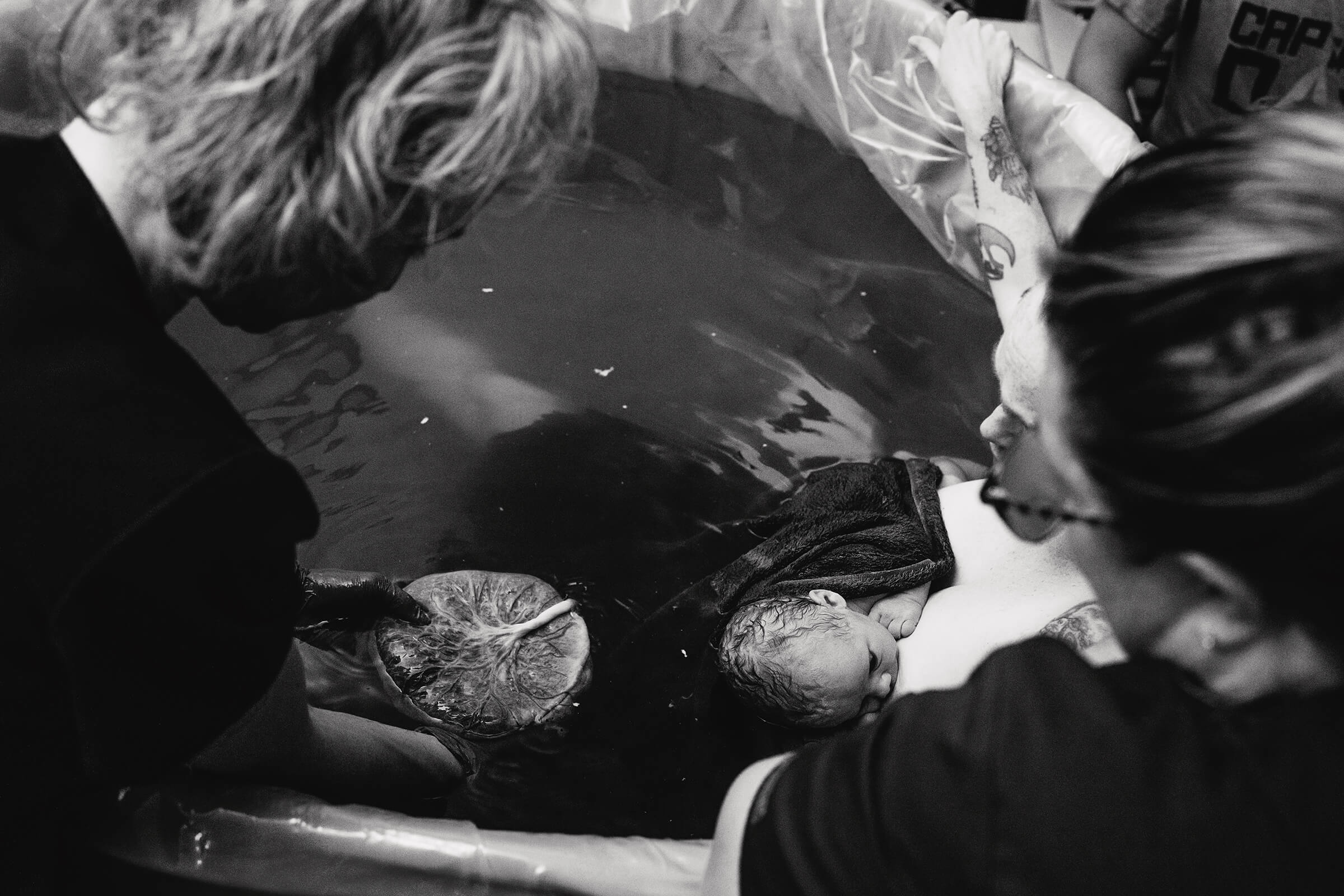 midwife showing details of placenta to her patient