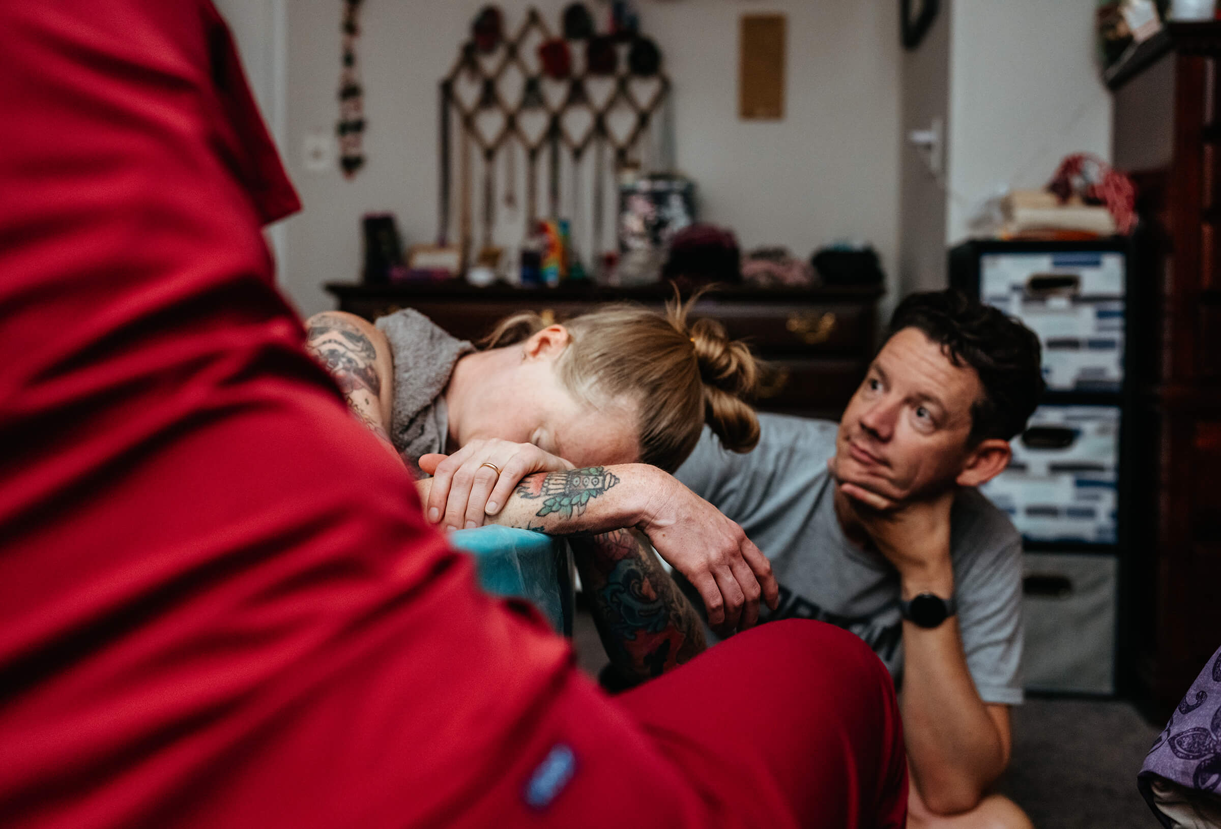 mother laboring in a birth tub with husband and doula supporting